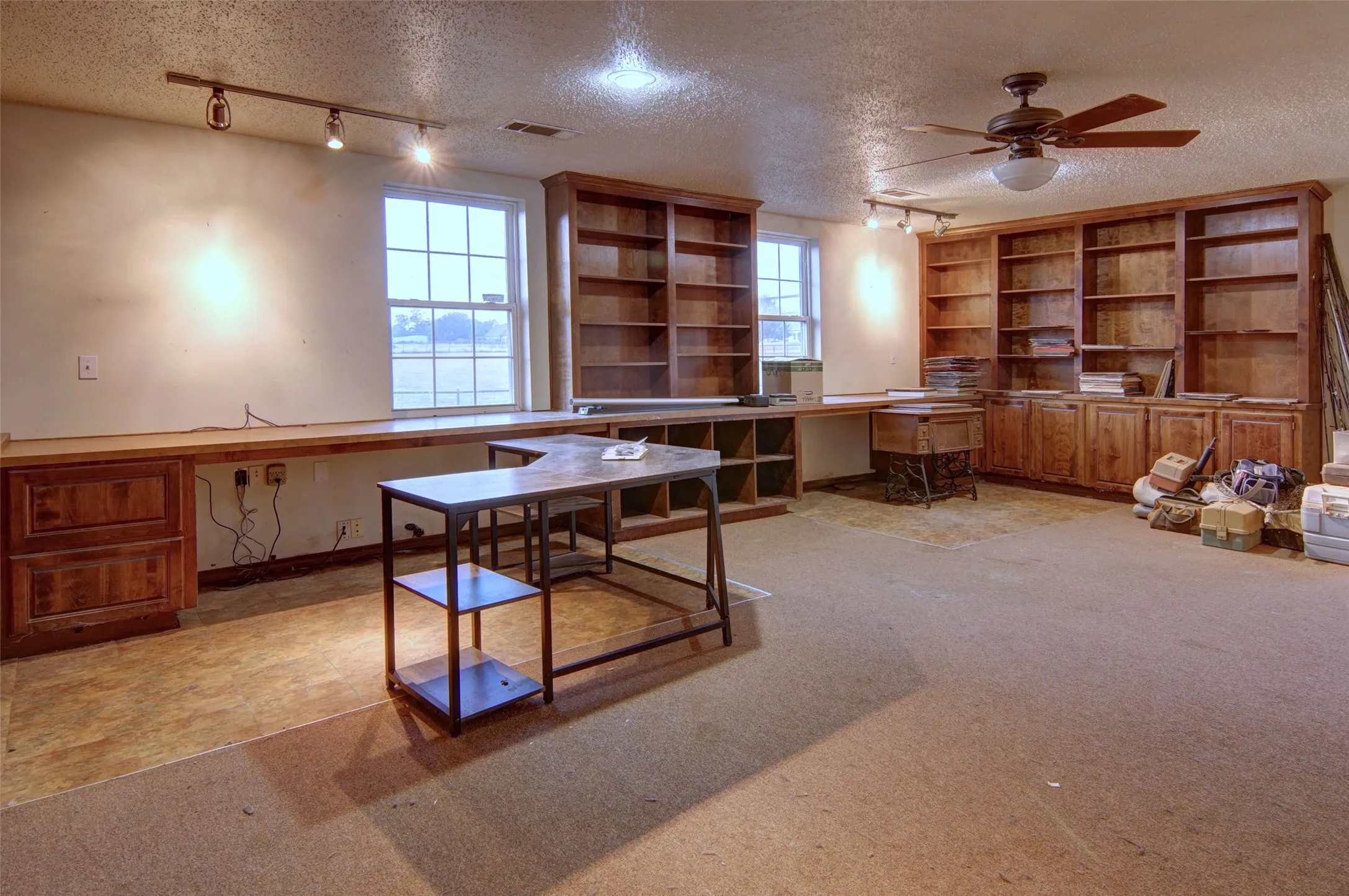Built-in wood cabinetry with integrated shelving, ceiling fan, and track lighting
