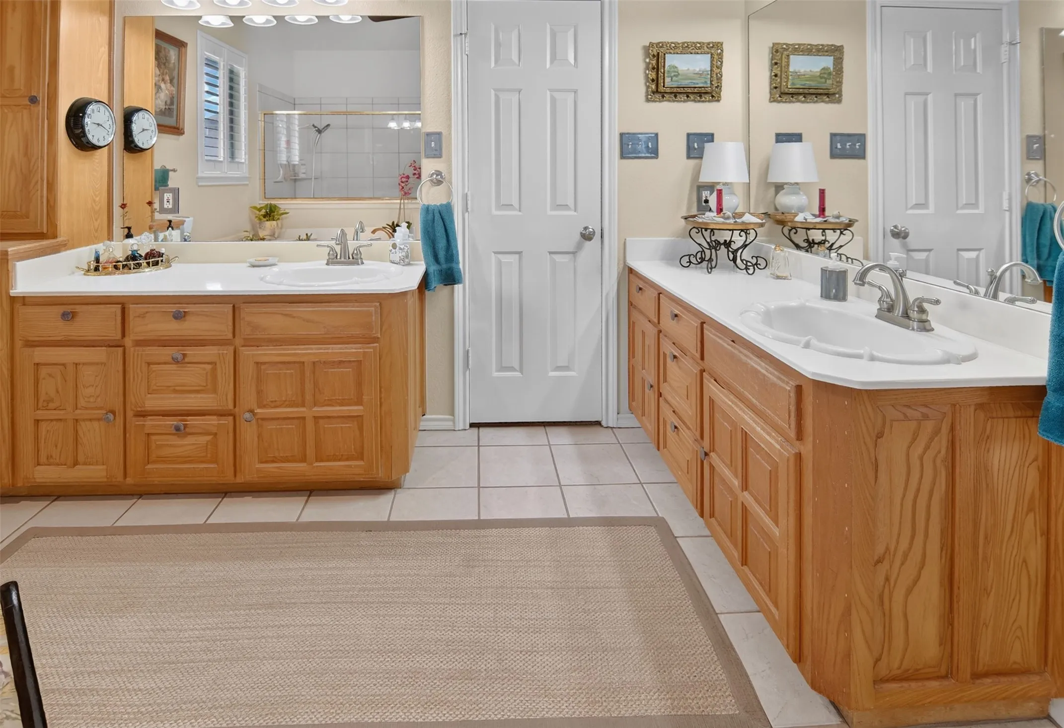 Two wood-finish vanities with white countertops and integrated sinks