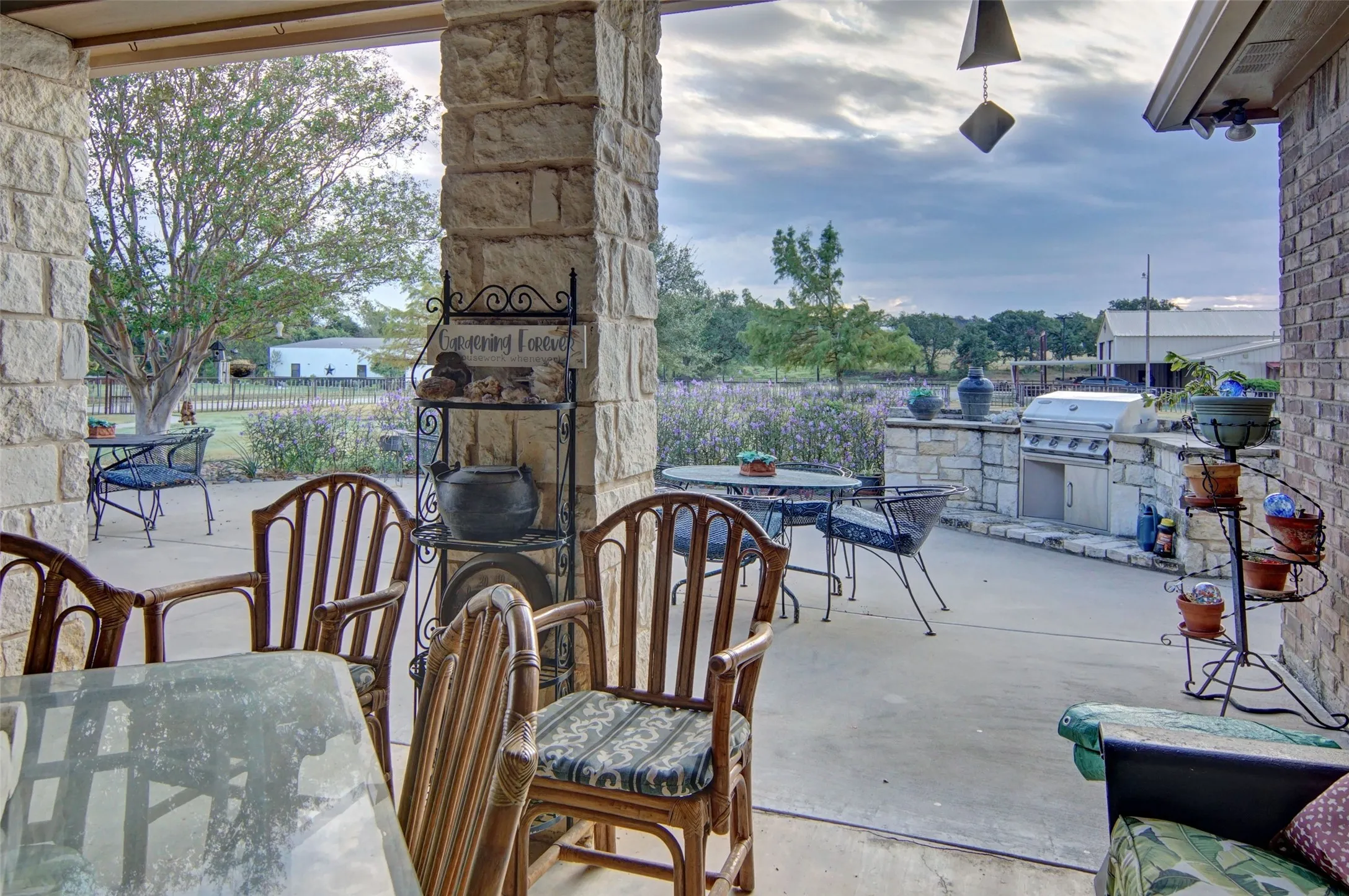 Covered patio featuring stone columns and a concrete surface