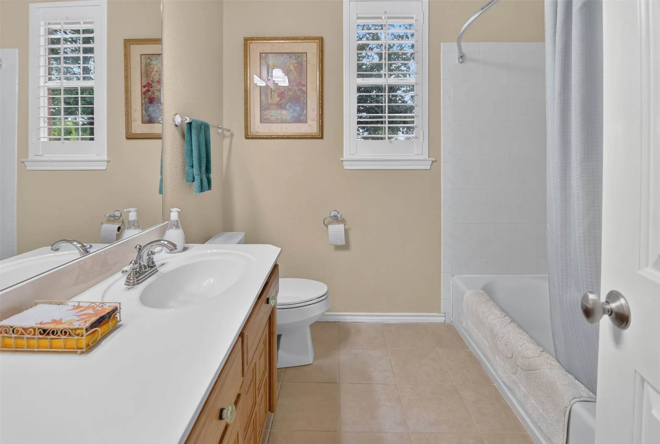 Bathroom featuring a single vanity with a white countertop, built-in wooden cabinetry, and a mirrored wall