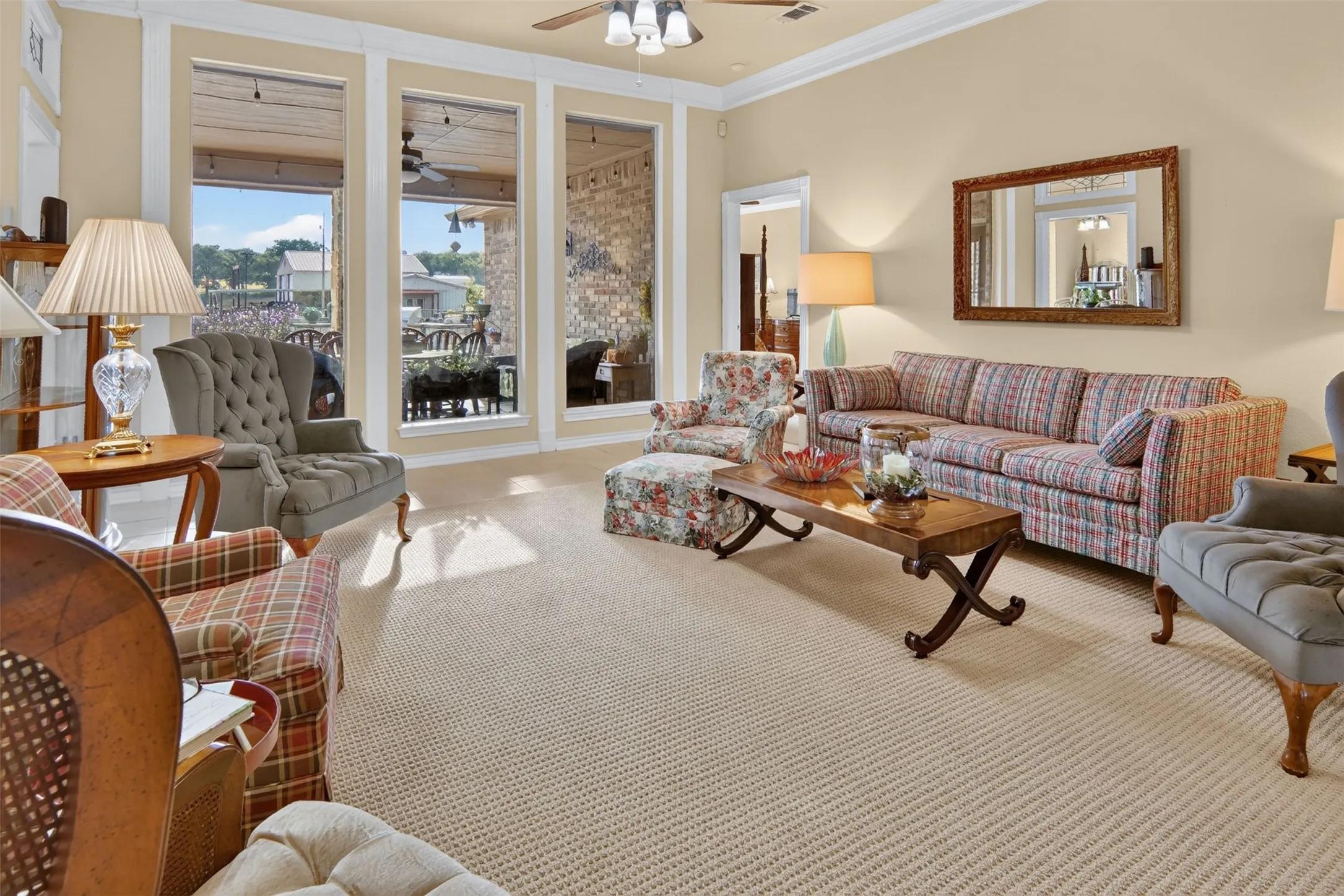 Bright, sun-filled living room featuring expansive multi-pane windows with scenic vistas, neutral wall finishes, and hardwood-finish flooring throughout