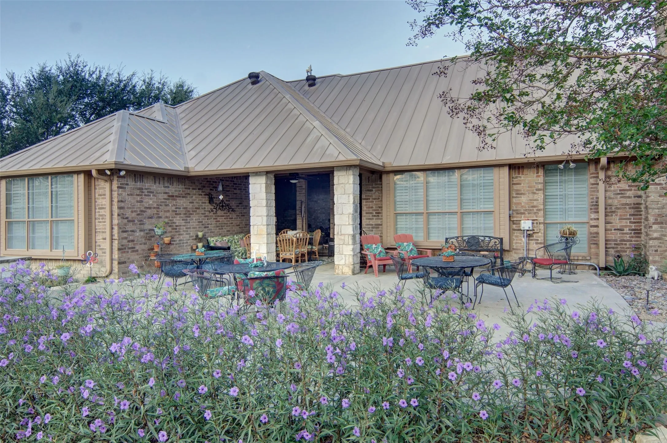 Expansive concrete patio with brick exterior and metal roof