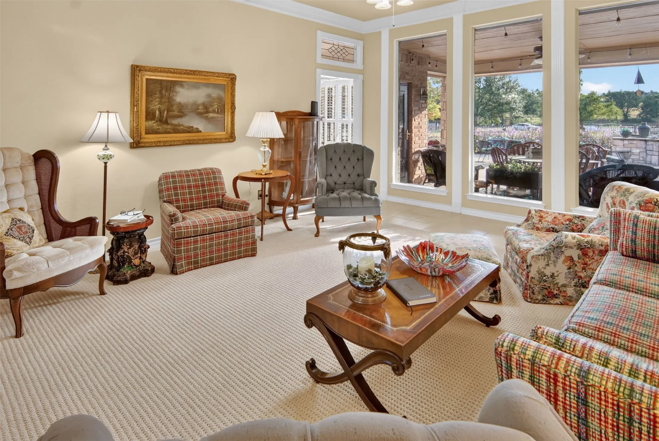 Neutral wall color, textured carpeting, crown molding, double glass paned doors, and multiple floor-to-ceiling windows