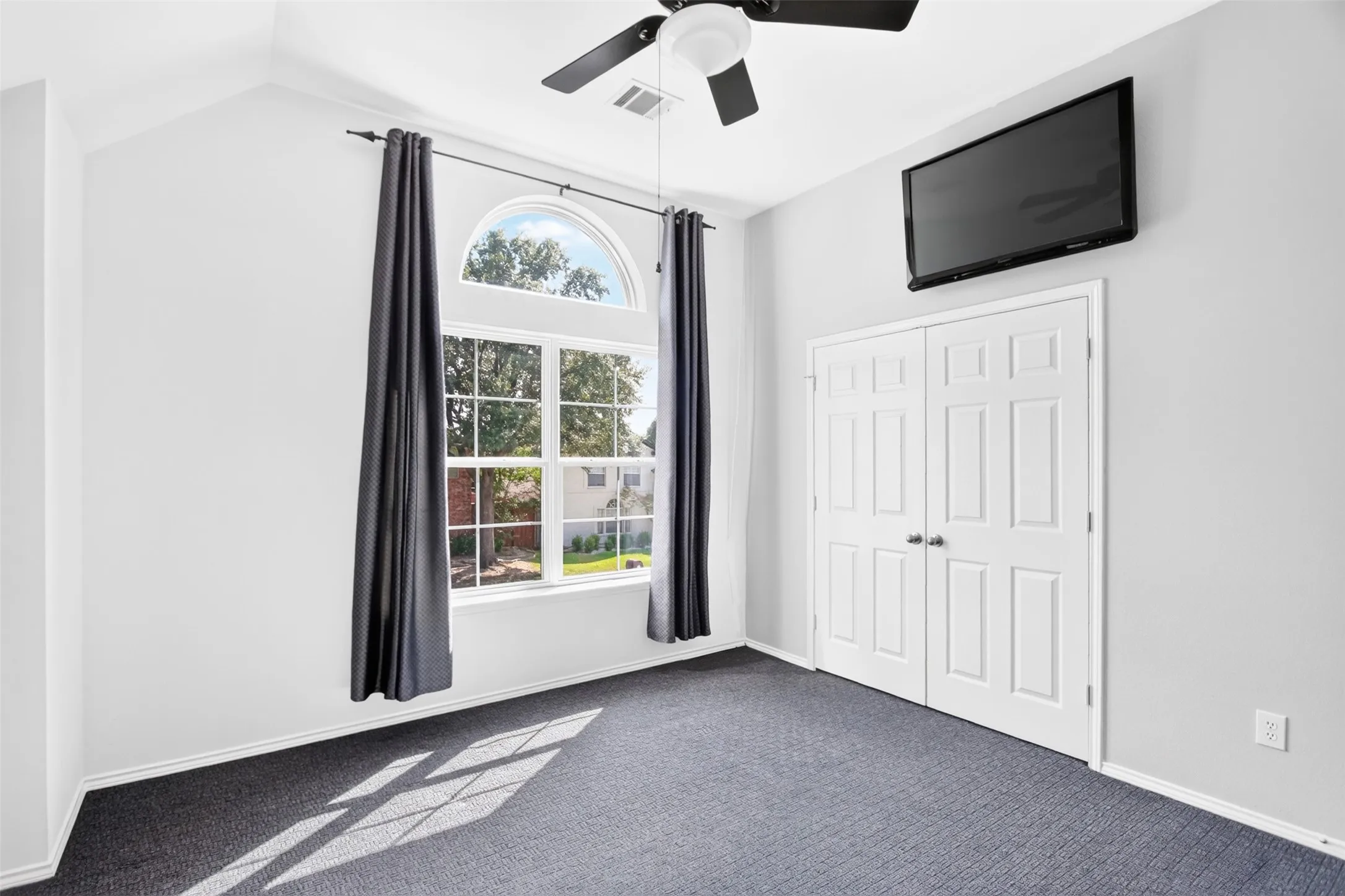 Full size secondary bedroom up with windows looking out on the street, full size closet and ceiling fan light fixture. Jack N Jill bathroom directly across. Floor to ceiling deep linen closet outside bedroom.