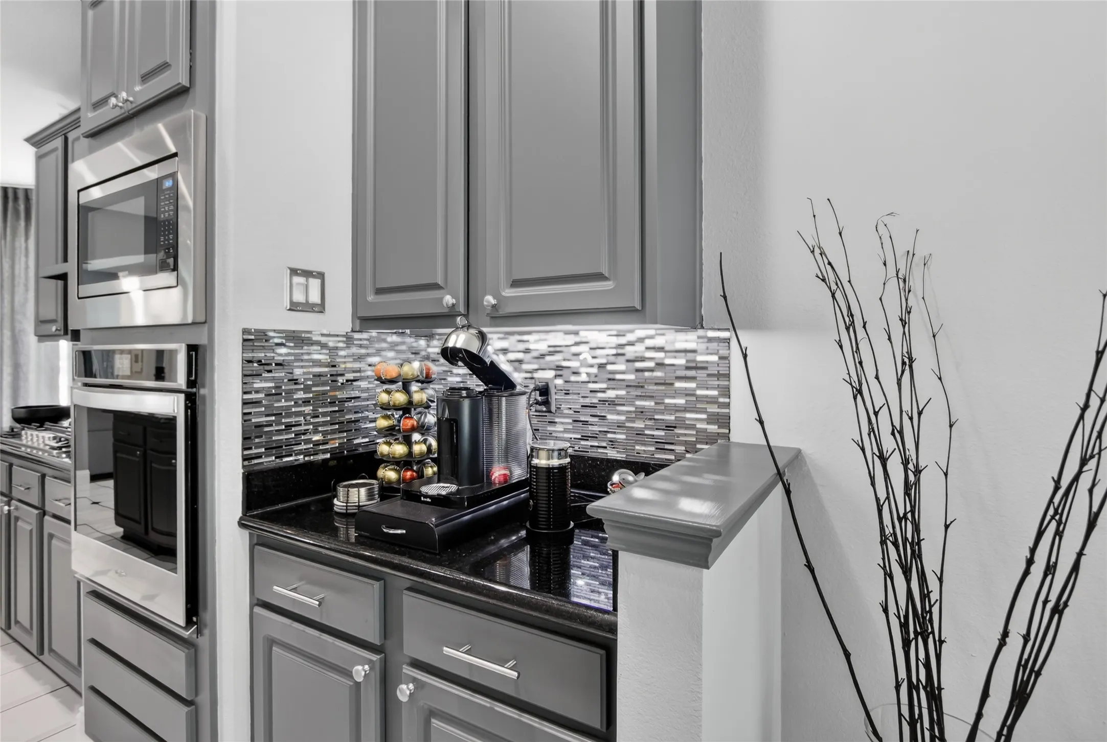 Thoughtfully designed dry bar or coffee station is conveniently located just off the kitchen, directly across from the pantry. Versatile space is an ideal area for staging dinnerware and serving pieces making entertaining effortless as the dining area is just a few feet away.