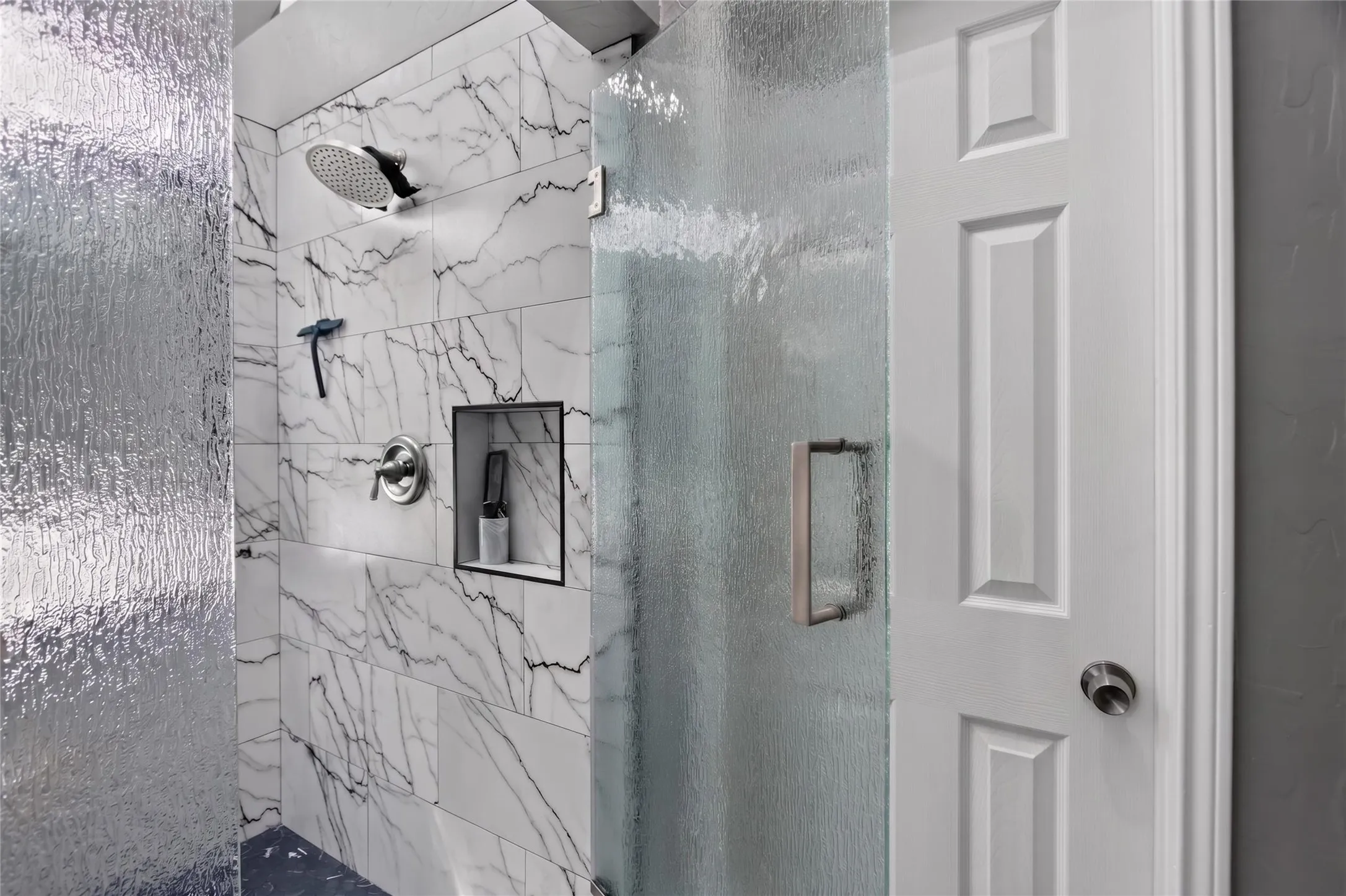 This oversized, updated remodeled shower completed in 2026 ($9000) features Rain shower head, privacy rain affect textured glass enclosure and stunning designer tile that compliments the bathroom's sophisticated color palette.