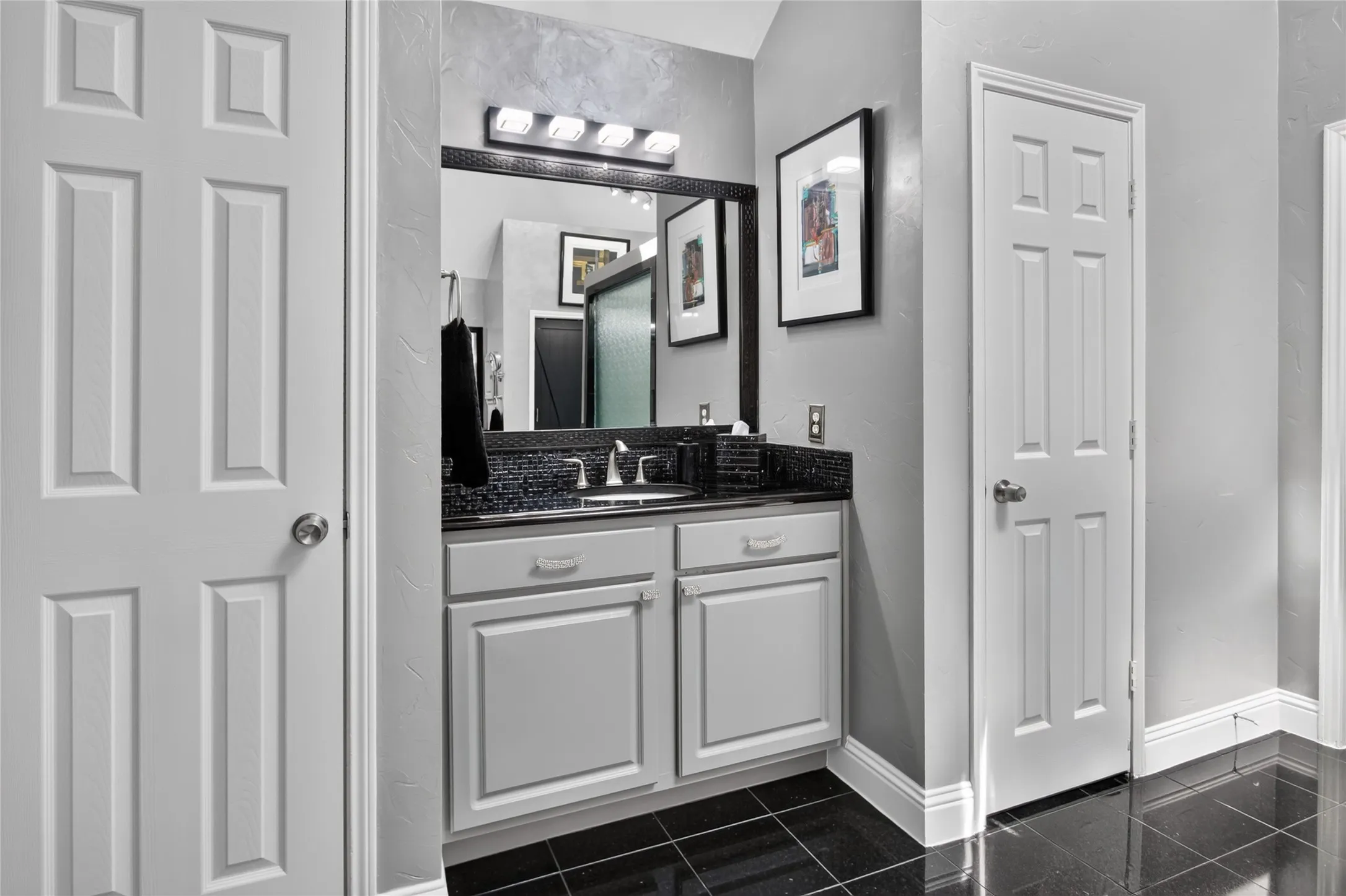 Vanity opposite the longer vanity in the Primary bath. Granite counter, updated light fixture and faucet. Full linen closet as well.