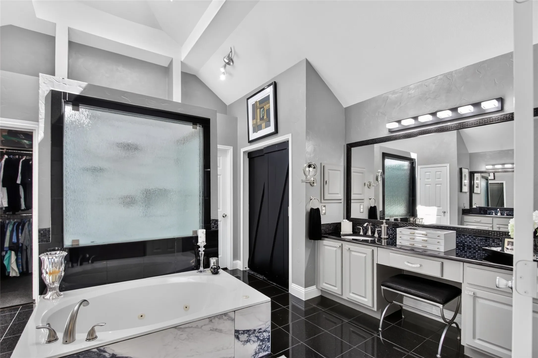 View of one of two separate vanities. Updated lighting, granite counter tops, full horizontal  mirror, medicine cabinet and so much counter space and cabinets. Large closet at the back with built-in cubbies and seasonal racks.