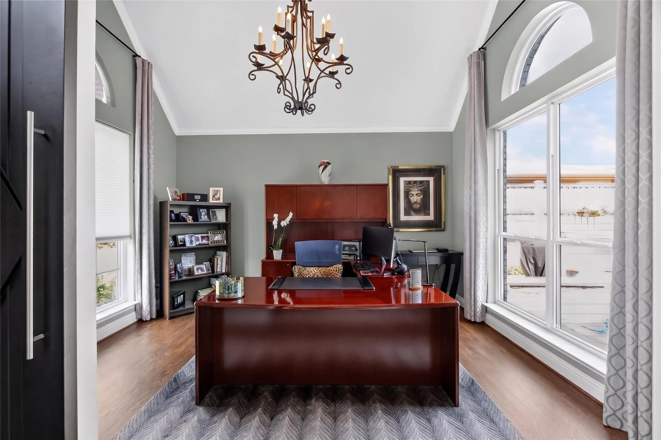 Home office has plenty of natural light with floor to ceiling windows looking out the front as well as out to your pool. Wood floors installed in office, dining and living room in 2007.  Neutral color walls accents most furniture. Check out this statement light fixture!