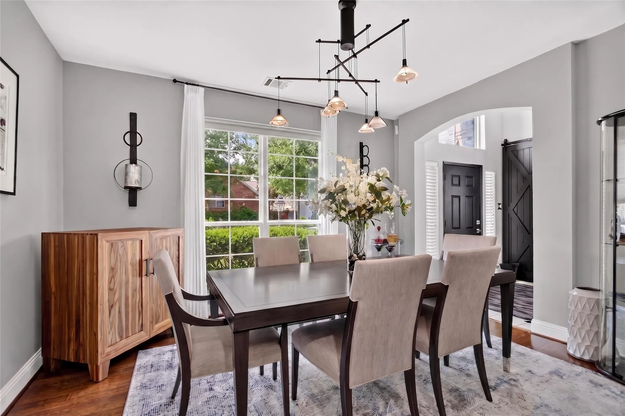 This stunning dining room, conveniently located just off the kitchen, is highlighted by a stunning designer light fixture and wood floors. Spacious enough to comfortably accommodate seating for 8 and ample space to add a hutch, curio cabinet or buffet, great for holiday gatherings.