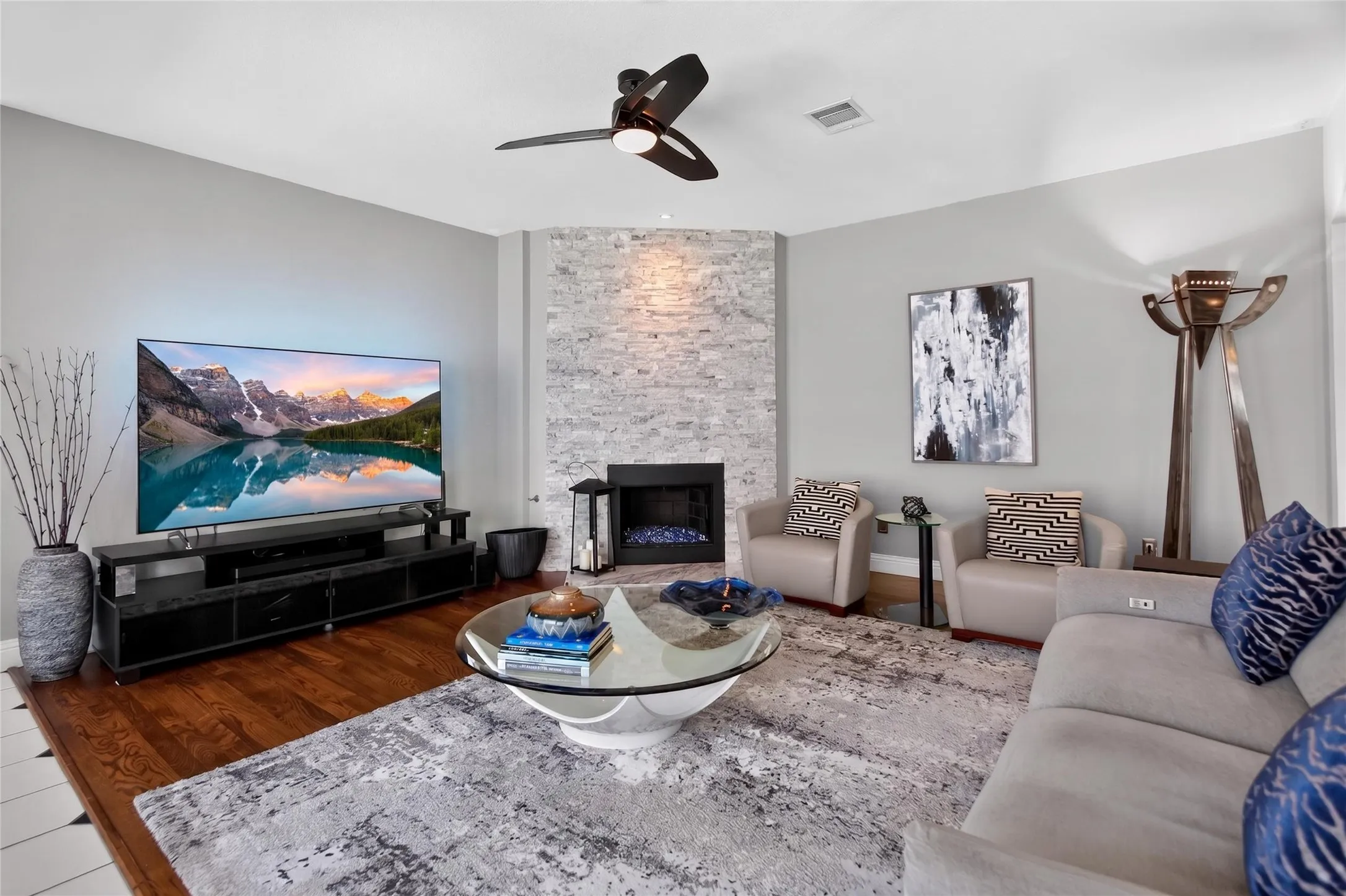 View of the floor to ceiling natural split stone gas fireplace. Fireplace remodeled in 2017.  Accent lighting enhances the beauty of the stone work.