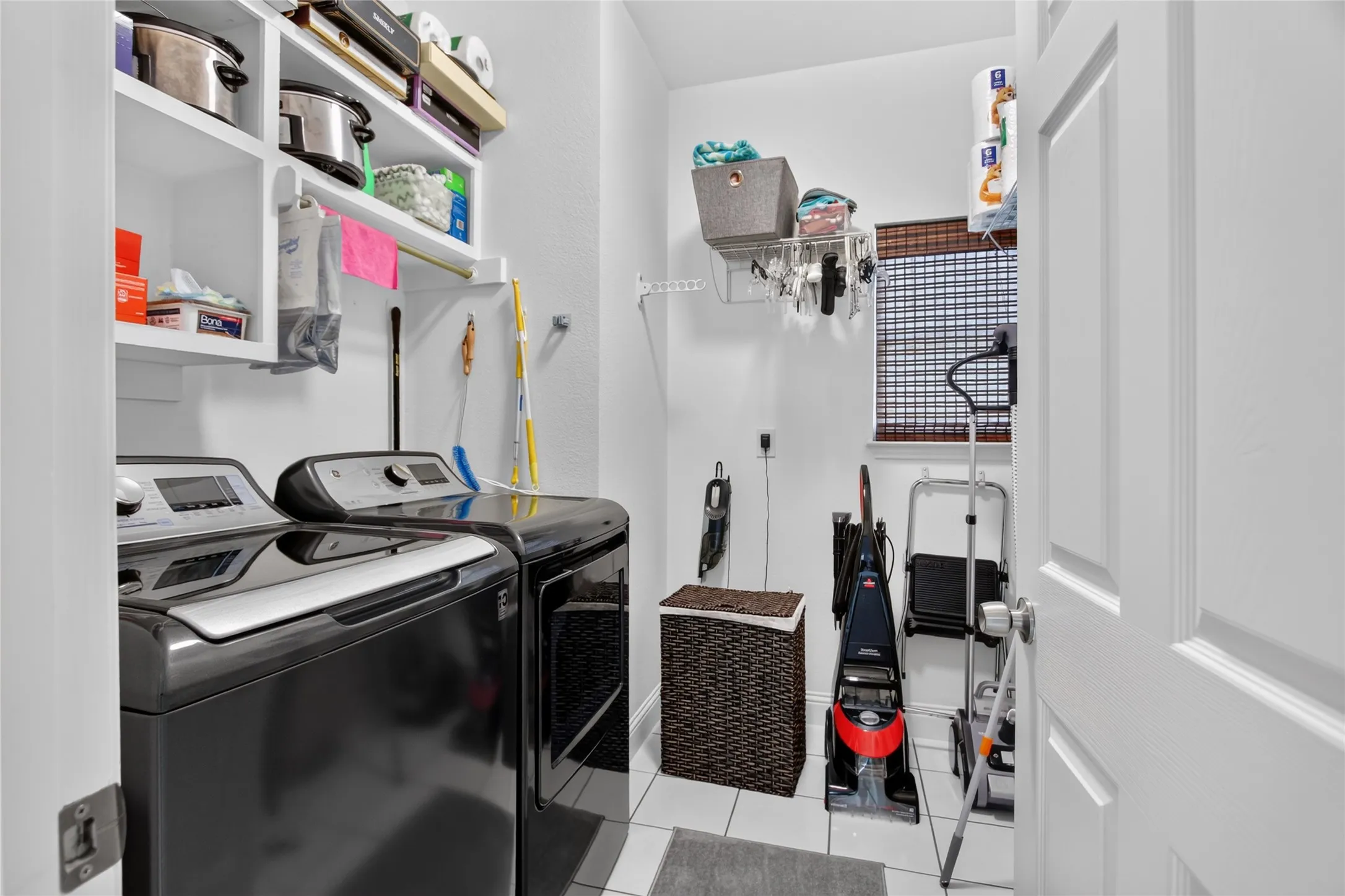 Utility room is oversized with room to add a refrigerator, sink or storage racks.  Tile floor and built in open shelves for ease of retreiving items. Room is on the first floor at the back of the home near your Primary retreat.