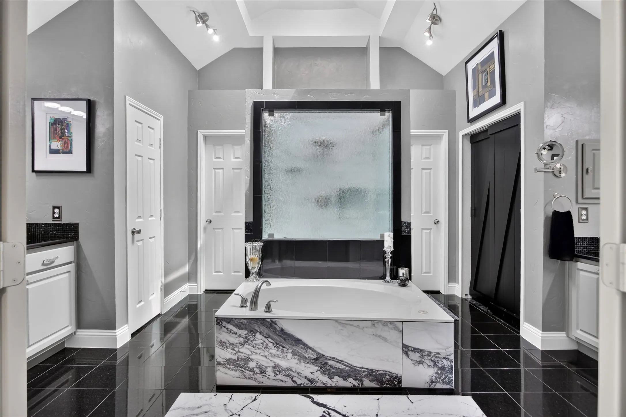 The primary bathroom is HUGE. Separate vanities and tile floor. Unwind in the luxurious marble surround soaking tube, creating a spa-like retreat.  Skylights were added in 2017 bringing in the natural light.