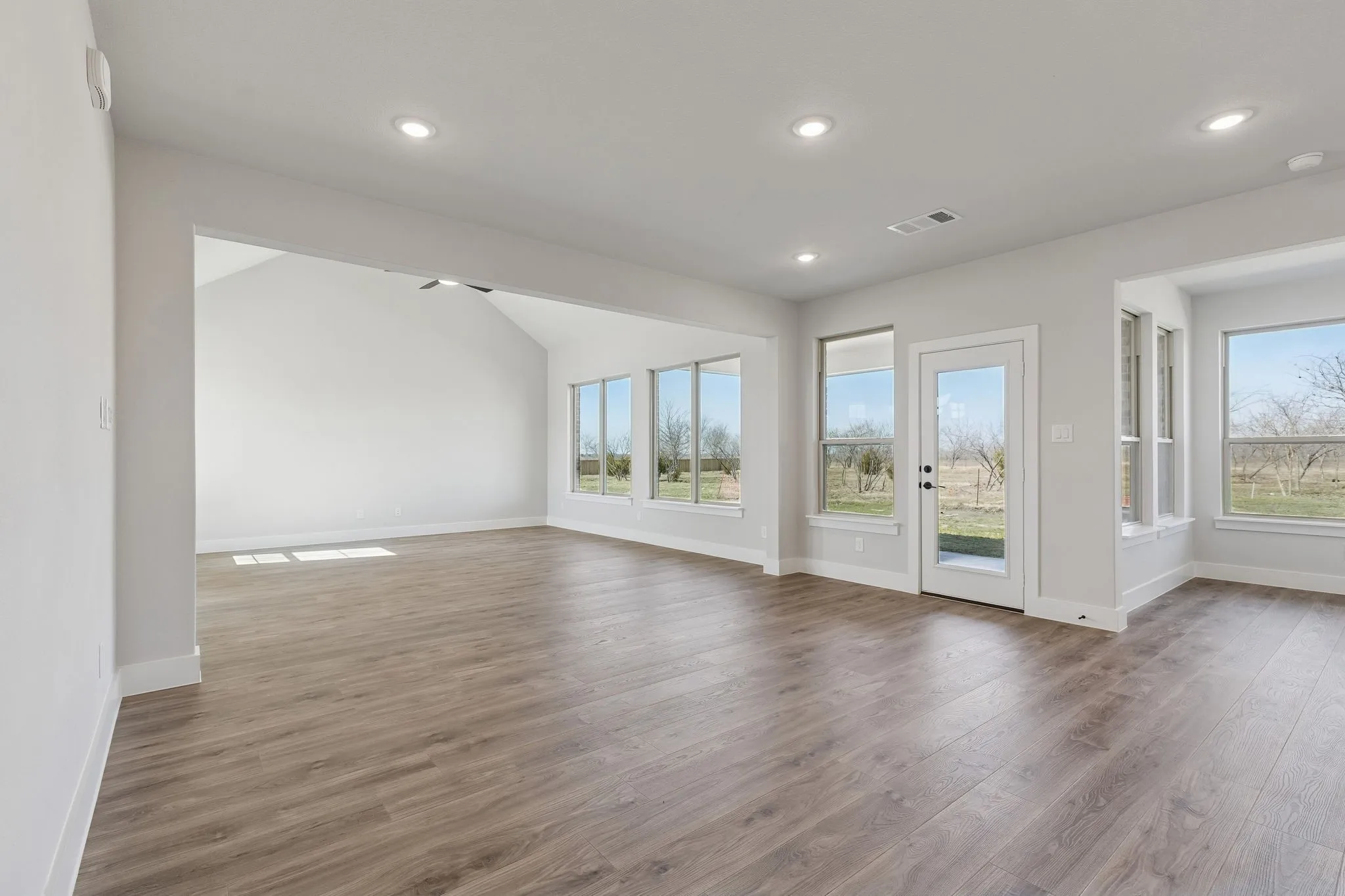 Wood-finish flooring throughout, recessed lighting, and a vaulted ceiling