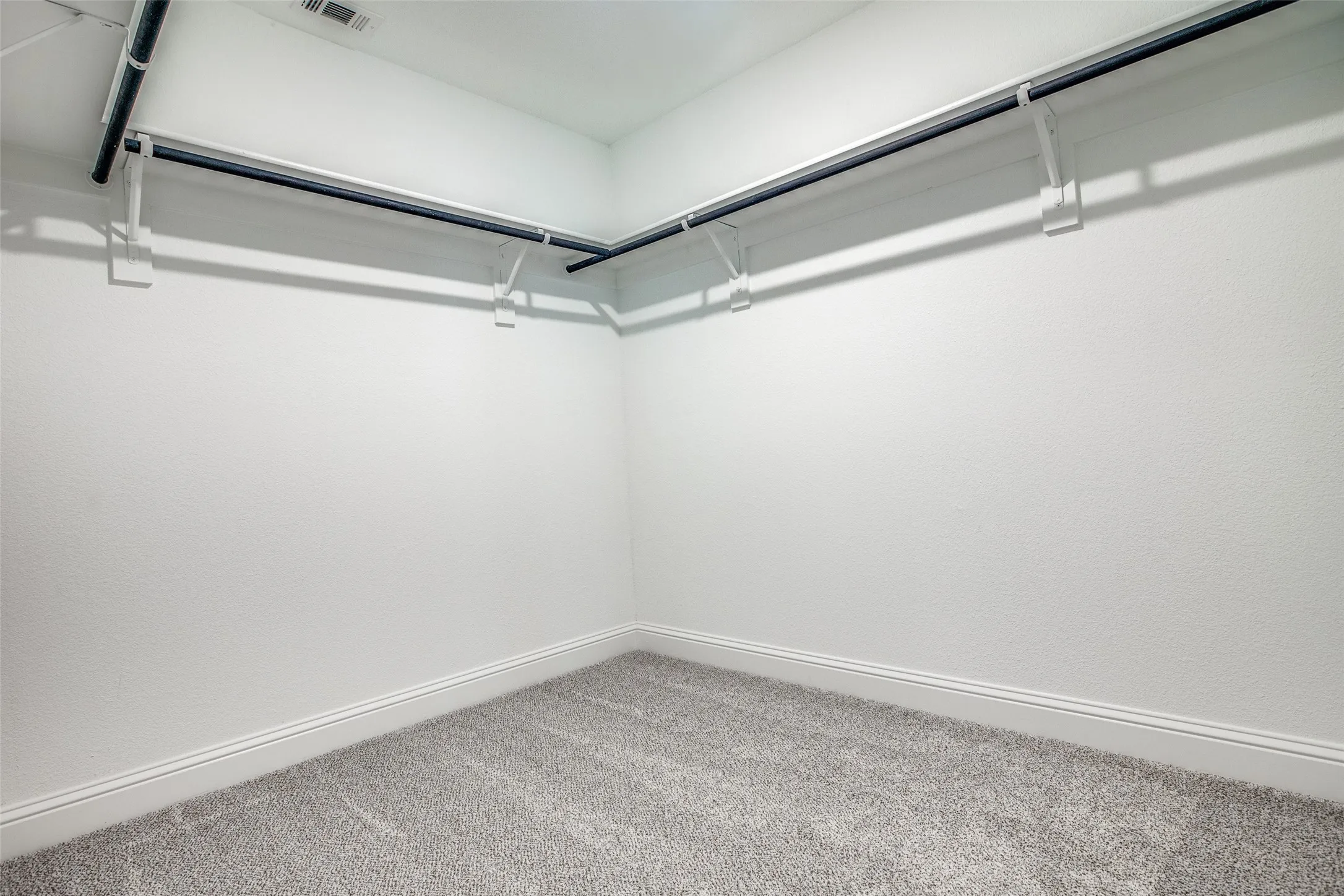 Gray carpeting with white baseboards and white walls