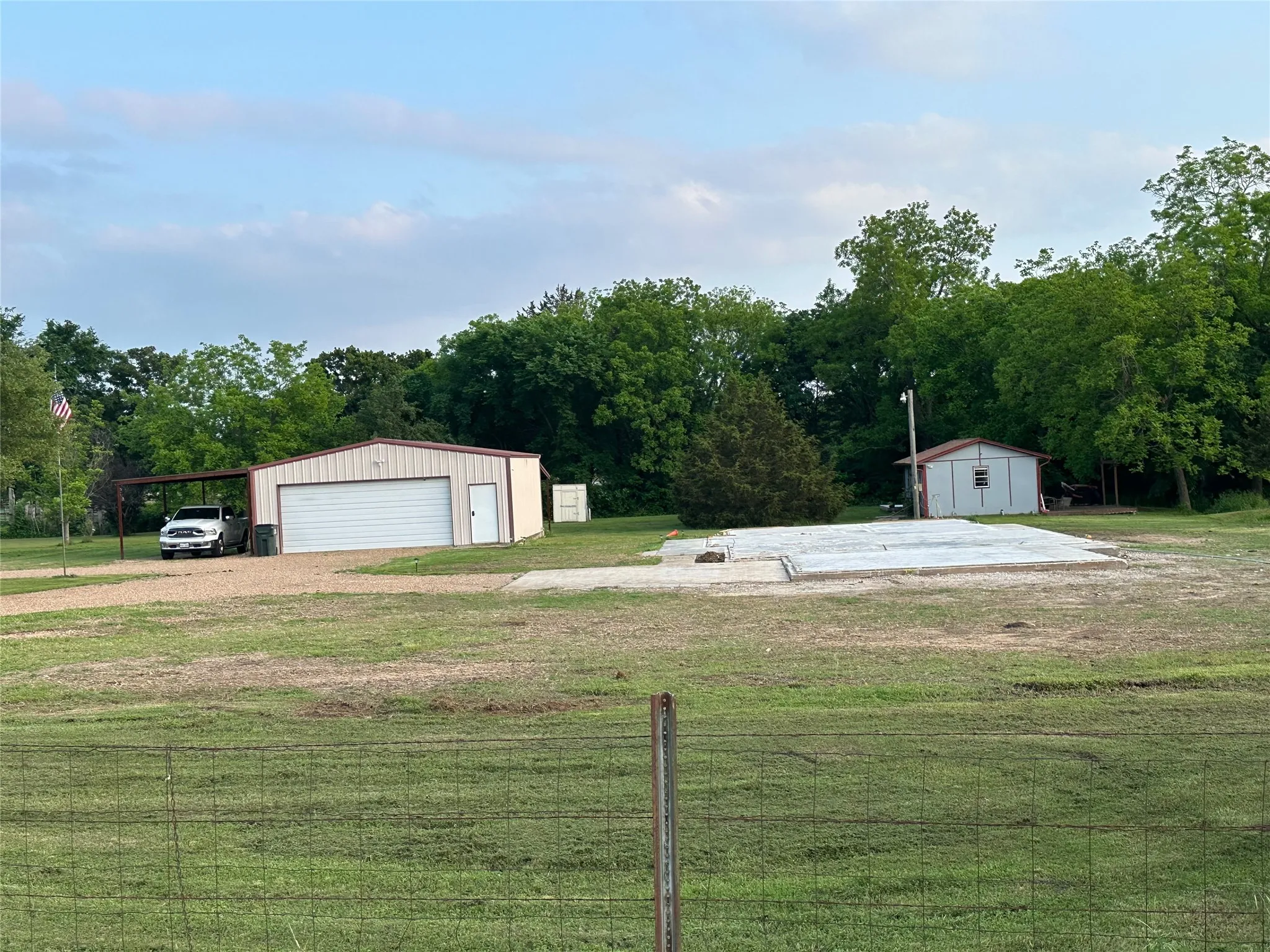 Metal outbuilding with a roll-up garage door and an attached carport