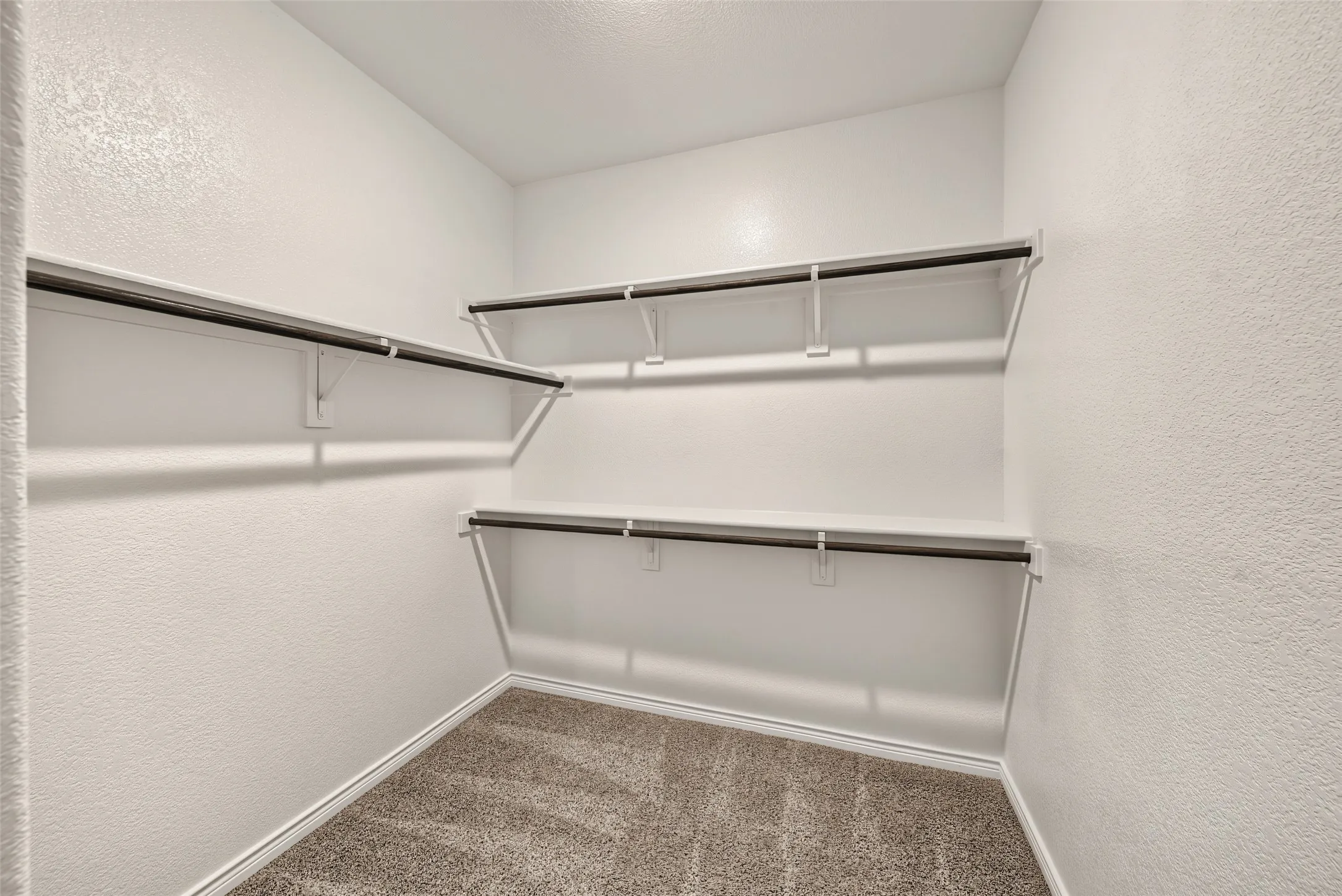 1 of 2  Primary closets with built-in shelving with hanging rods