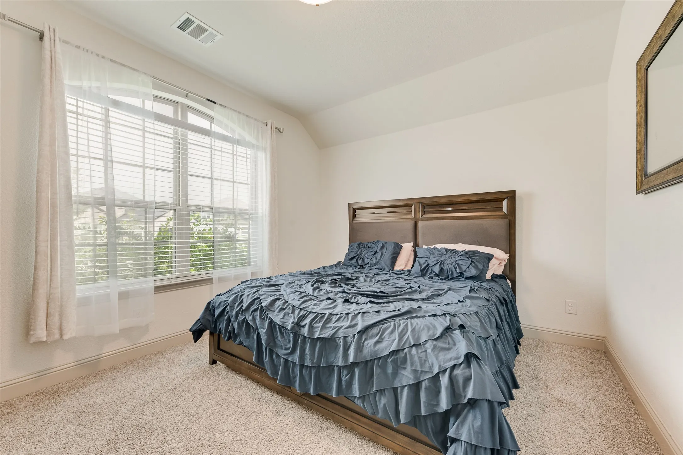 Large window with horizontal blinds, light-toned walls, and carpeted flooring