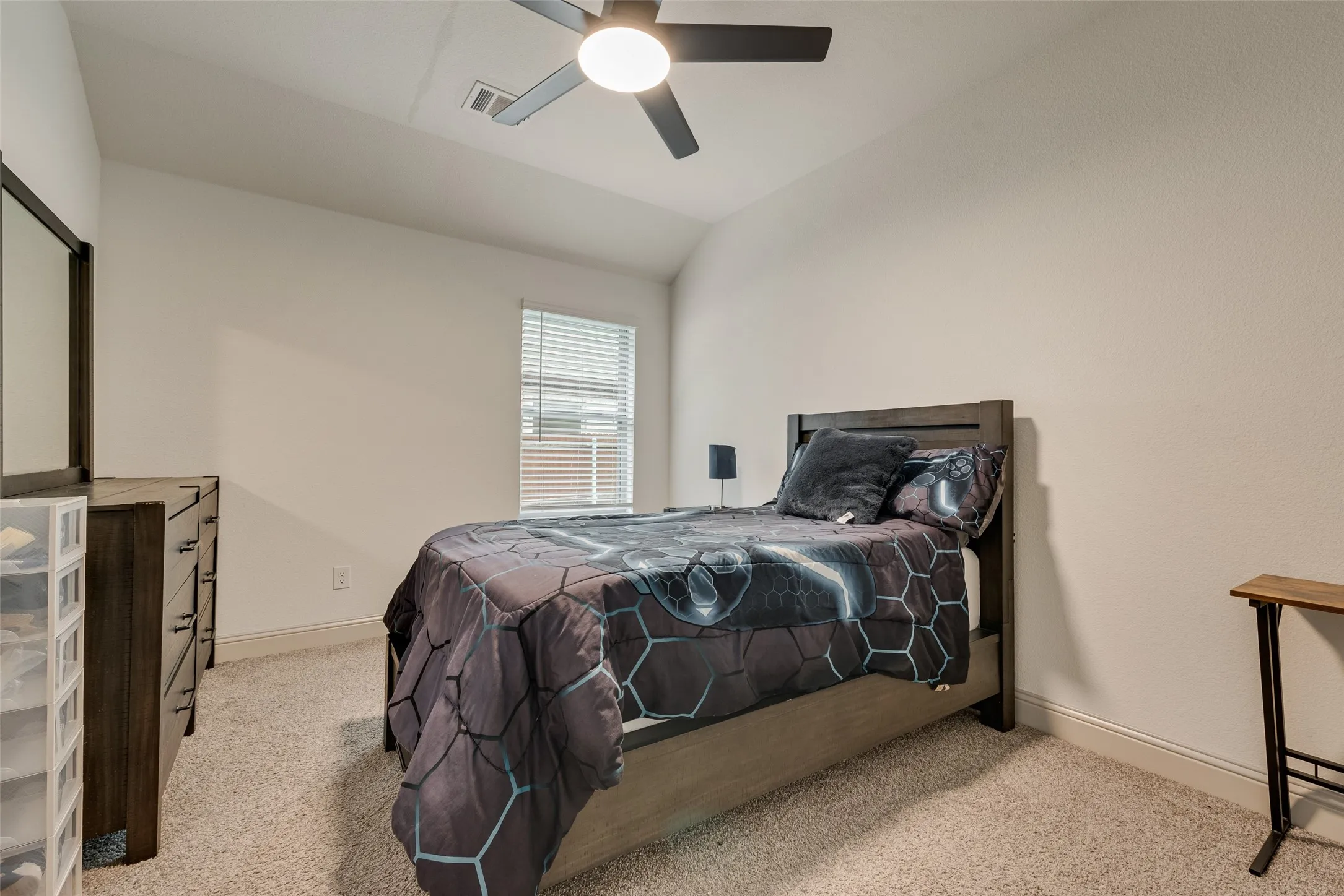 Carpeted bedroom with a ceiling fan and light fixture, a window with blinds, and light-toned wall paint