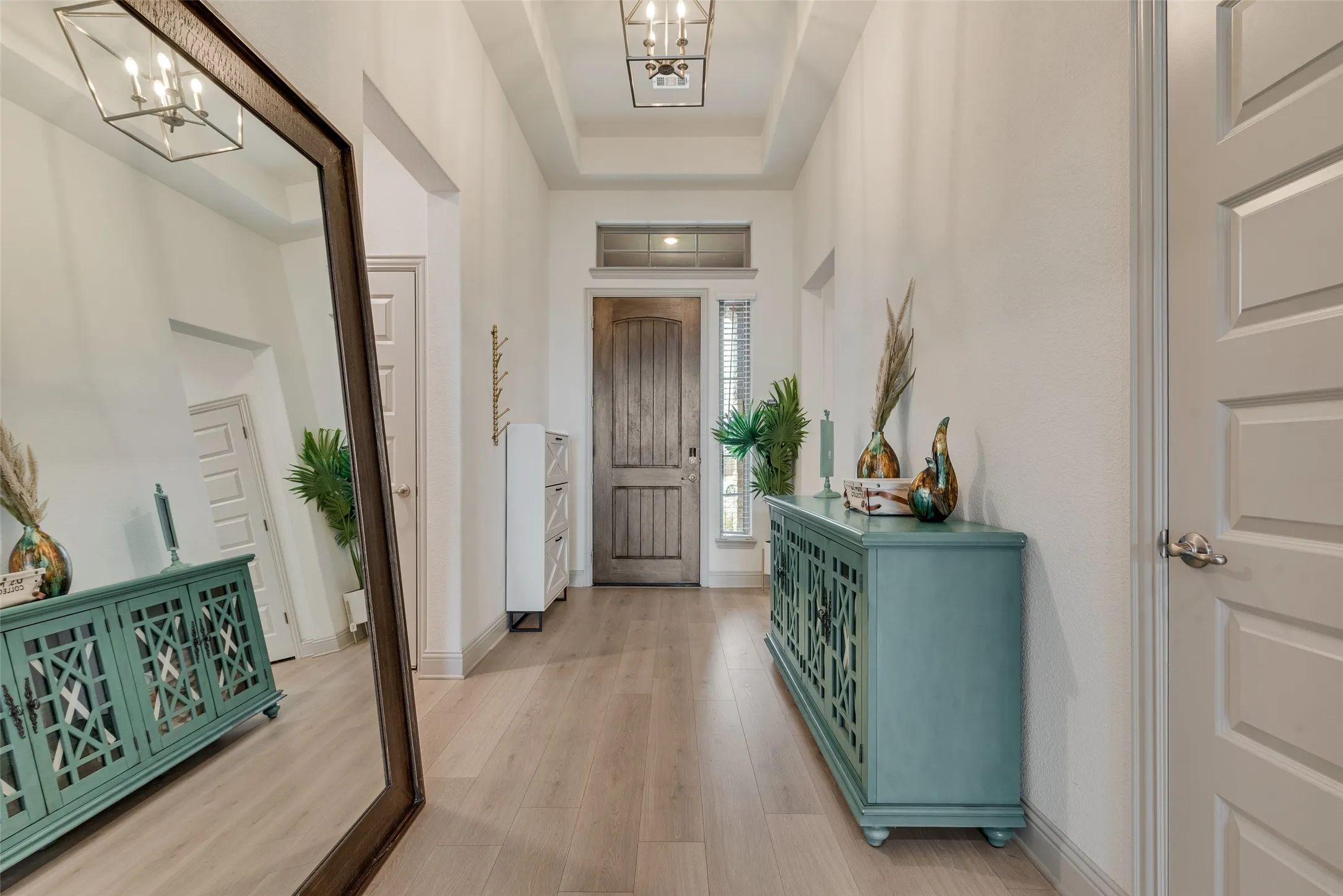 Entrance foyer with tray ceilings, recessed lighting, and wood-finish flooring
