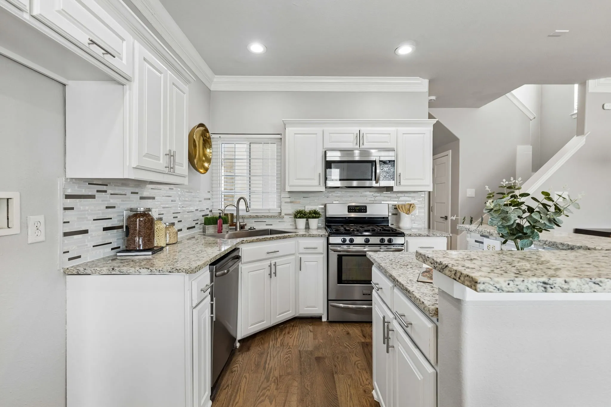 White cabinetry with brushed nickel hardware, mosaic tile backsplash