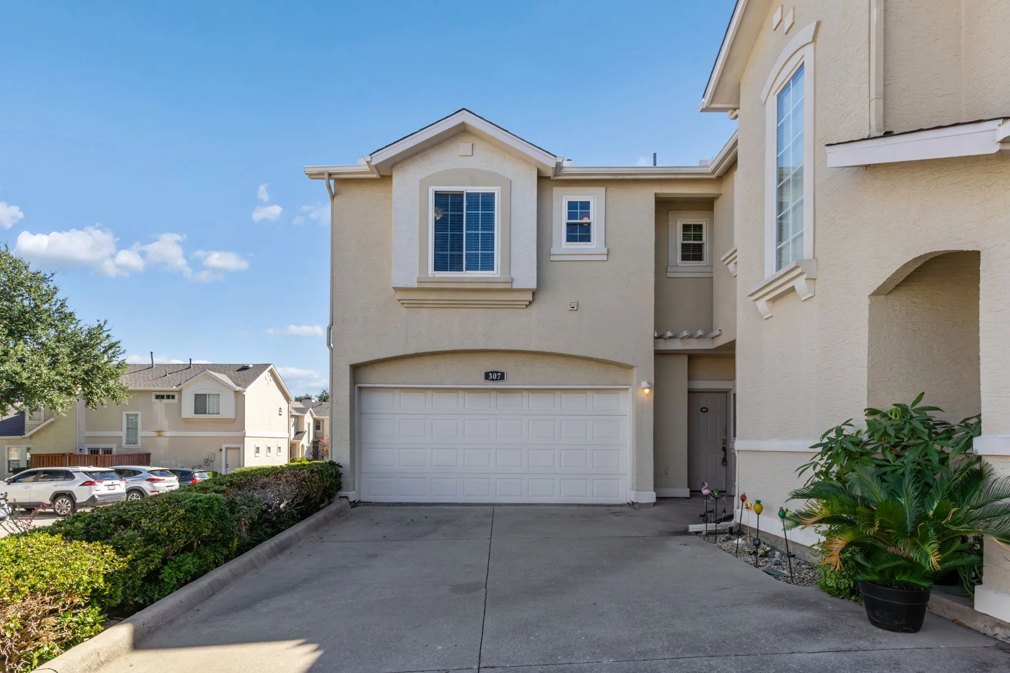 Stucco exterior residences with multiple attached garages, gabled roofs, and chimney accents