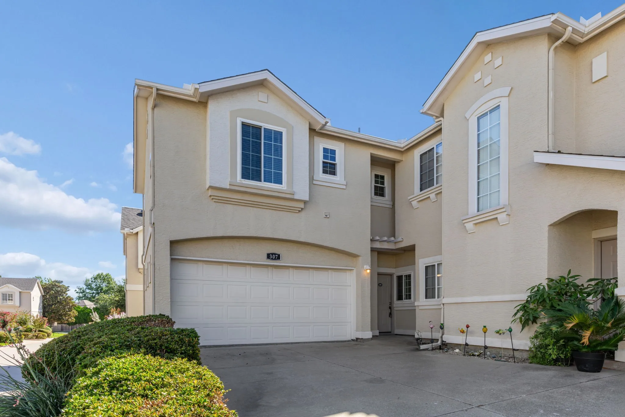 Stucco exterior with arched entryways, decorative window accents, and an attached garage