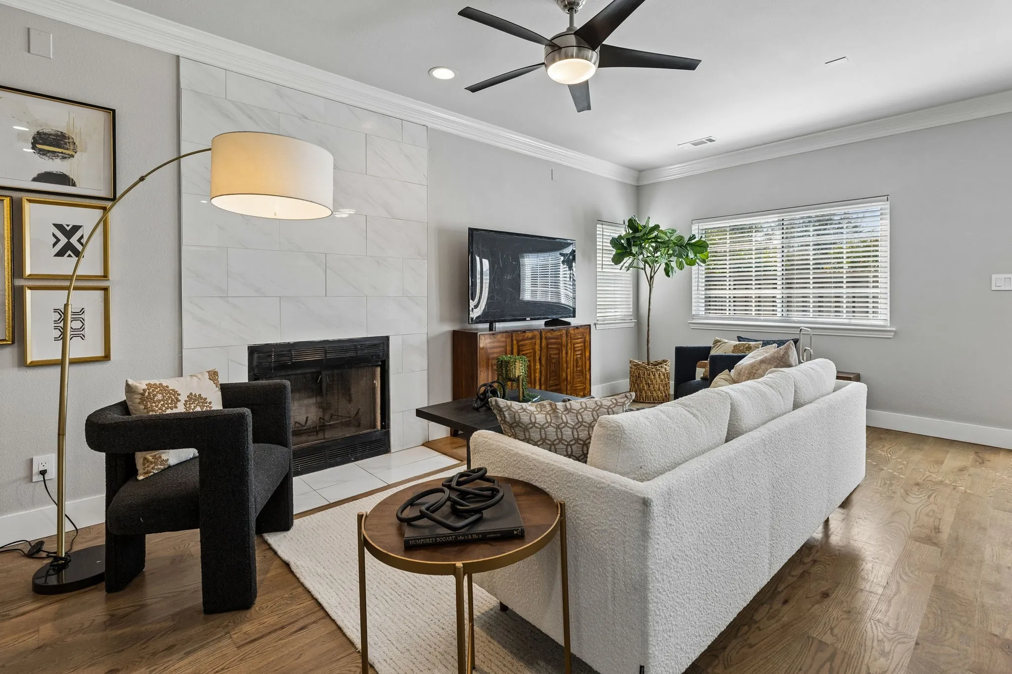 Recessed lighting, crown molding, a ceiling fan, and a fireplace with a tile surround