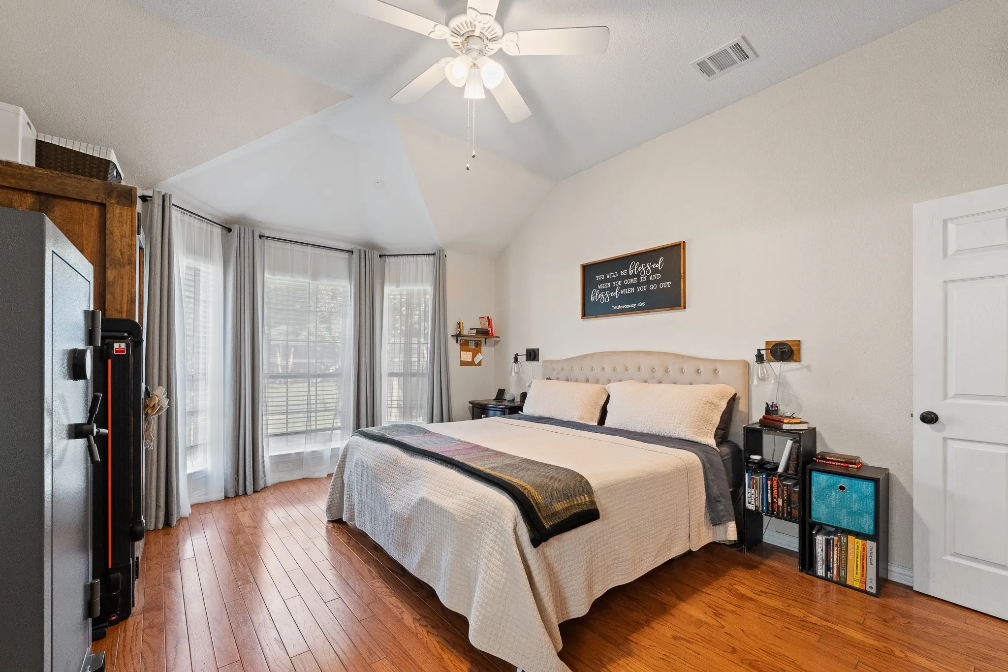 Vaulted ceiling, ceiling fan, wood-finish flooring, bay window, paneled interior door