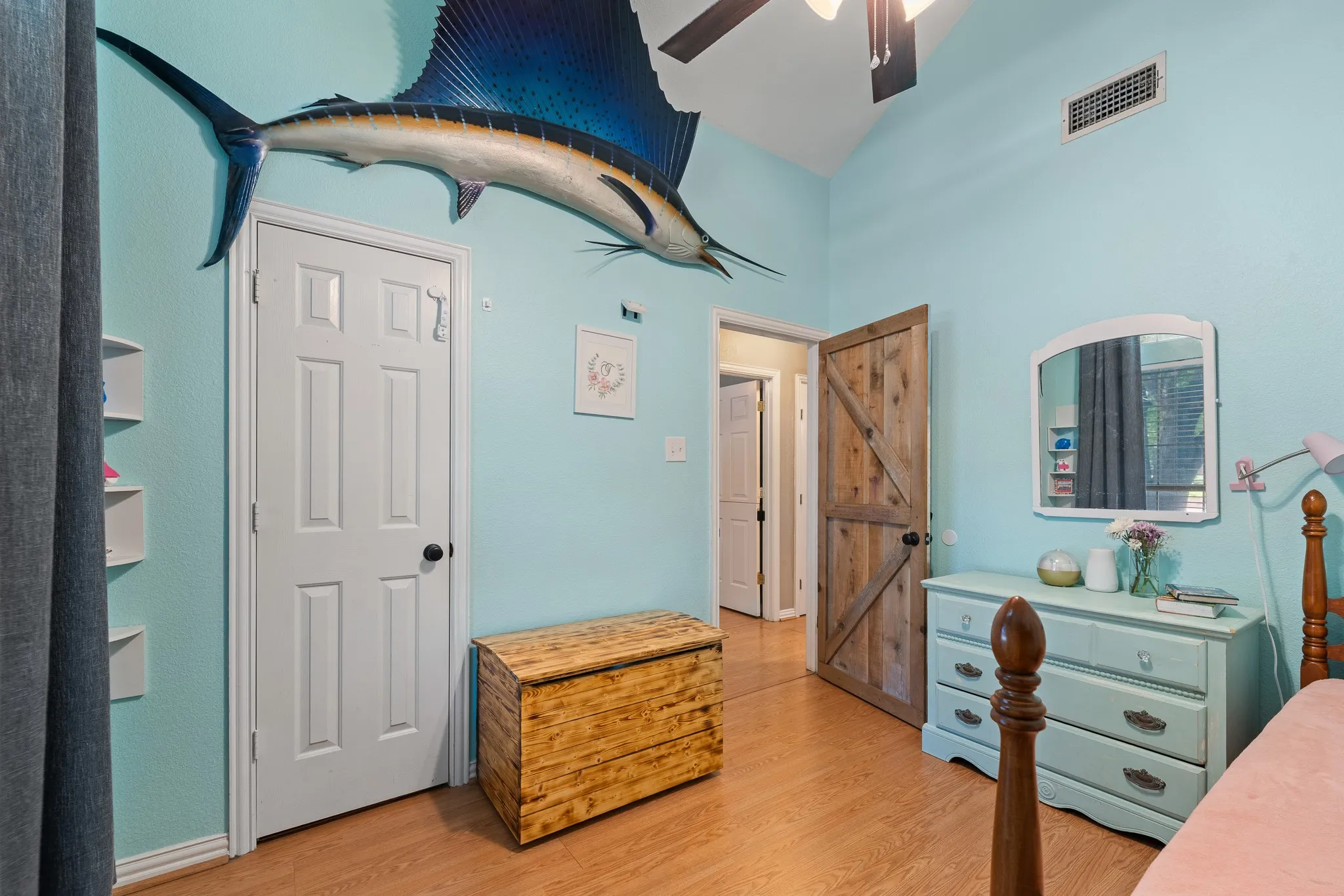 Vaulted ceiling with a ceiling fan, wood-finish flooring, and white trim