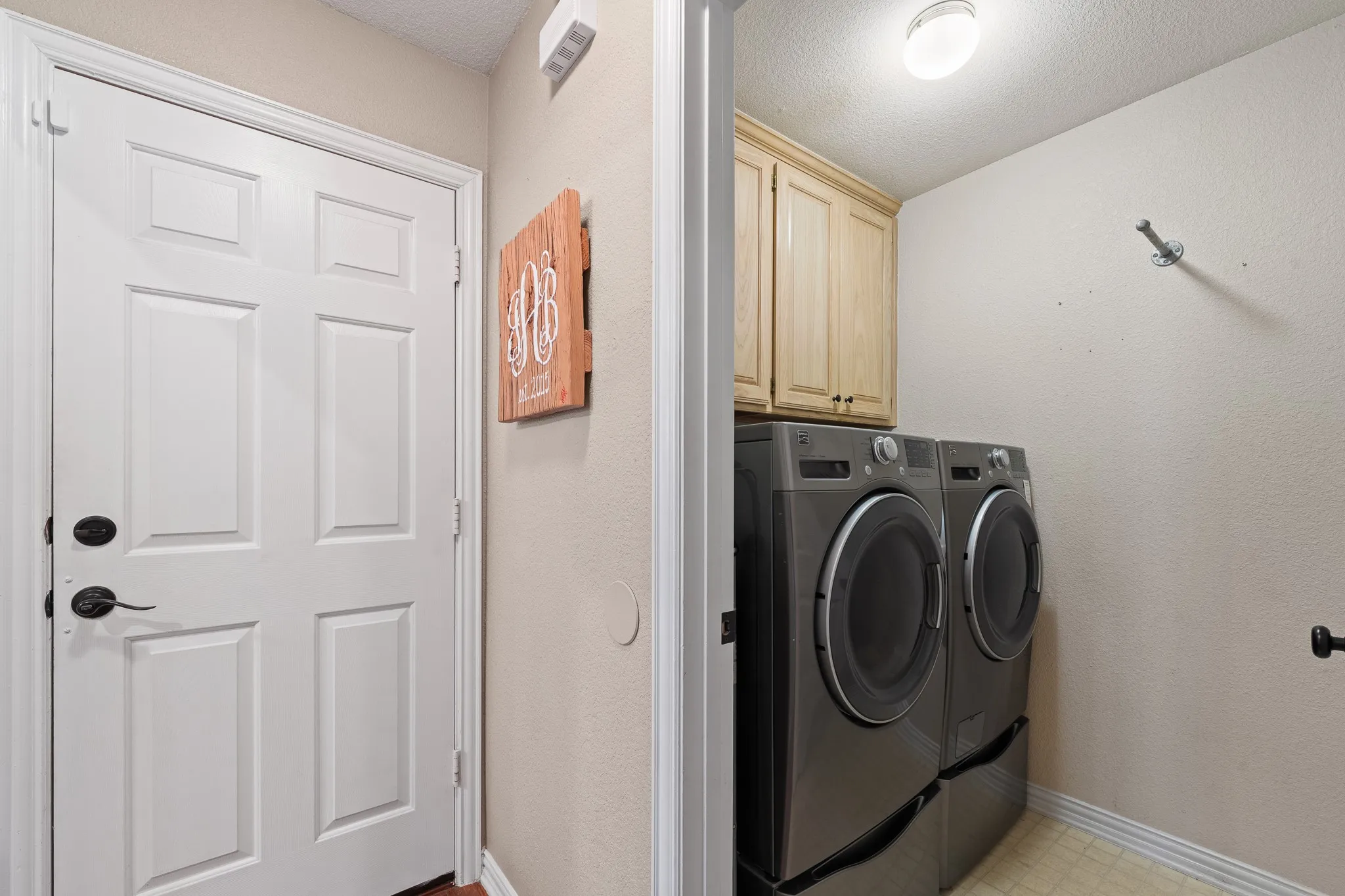 Laundry area featuring overhead cabinetry