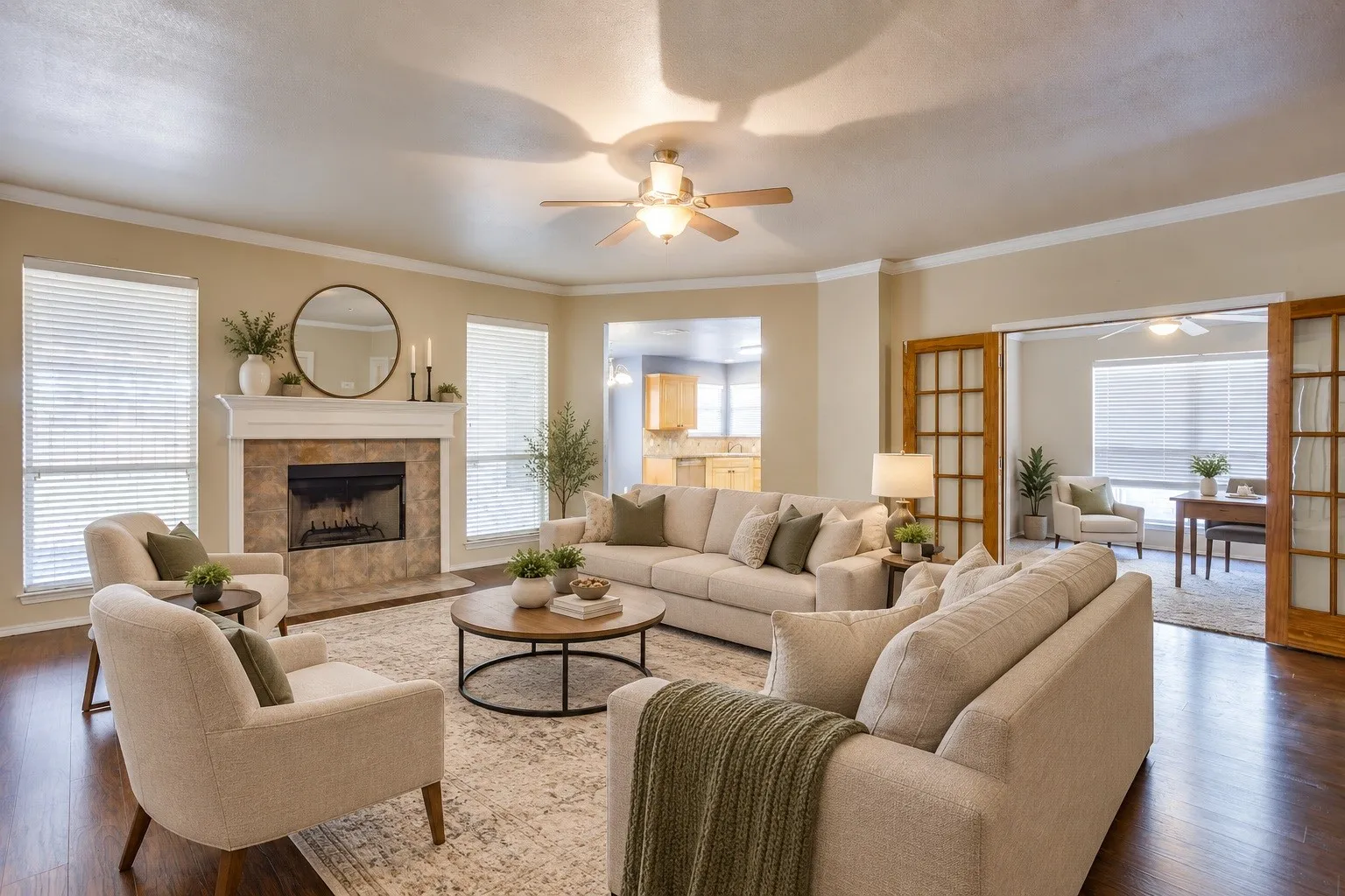 Living area featuring a stone-faced fireplace with a white mantel, wood-finish flooring, and crown molding.  virtually staged with AI
