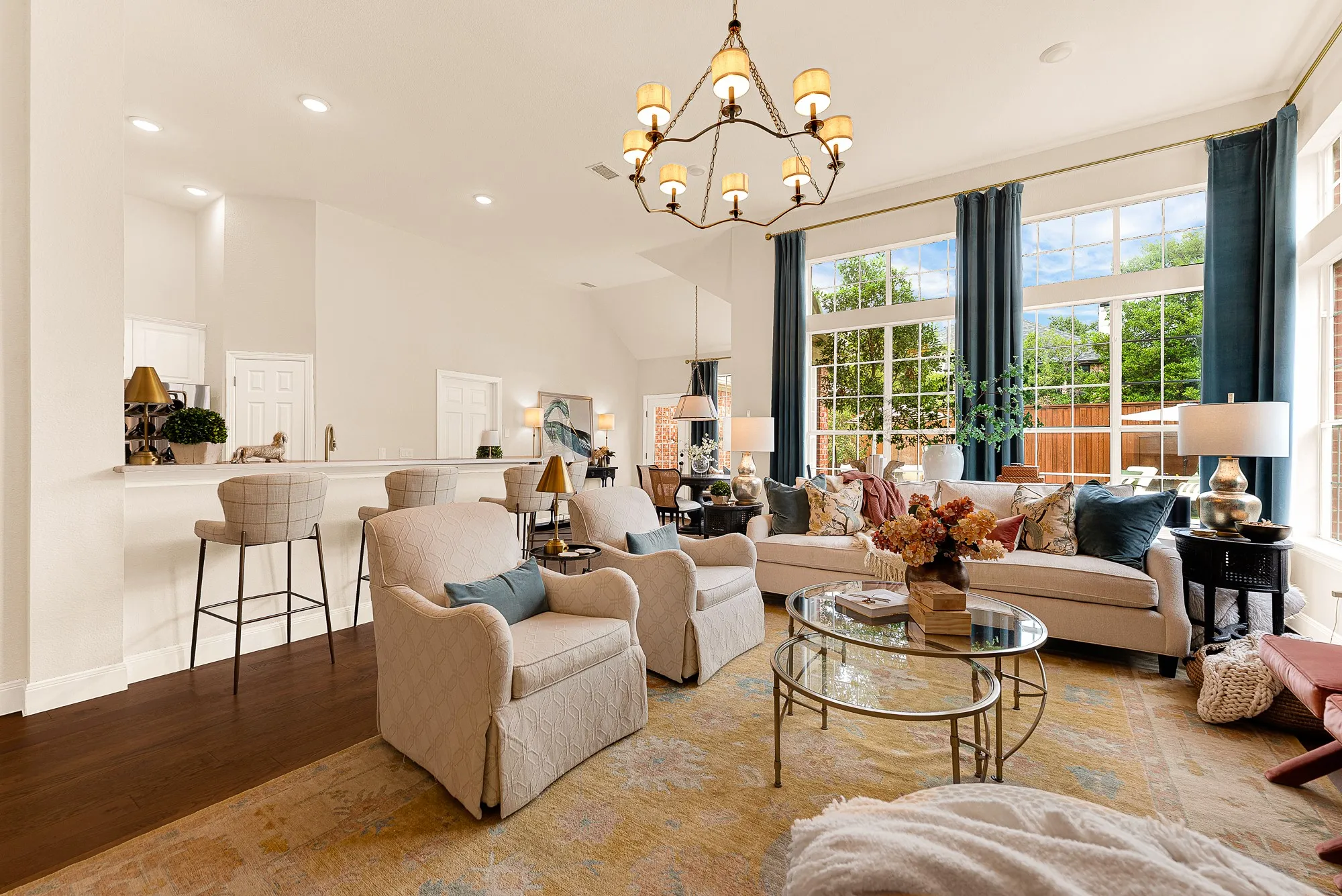 Soaring ceilings and expansive wall-to-wall windows frame vibrant outdoor views, flooding the space with bright midday light. Enjoy effortless weekend afternoons chatting with guests at the bar while keeping an eye on pool activities.