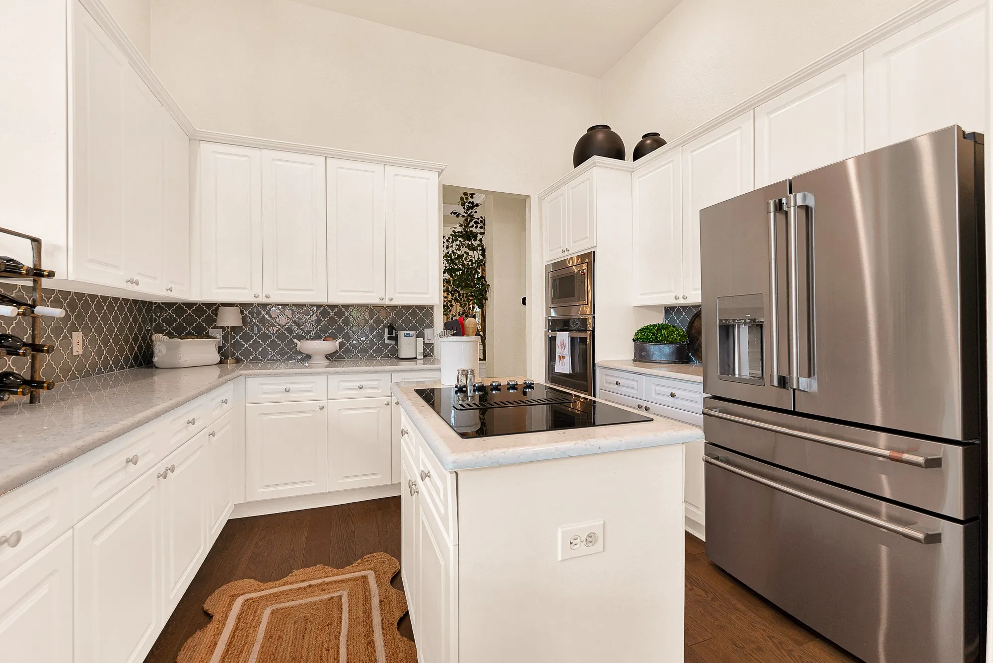 An upgraded arabesque backsplash brings rich contrast against crisp cabinetry and sleek stainless steel built-in appliances. Enjoy crafting gourmet recipes using modern cooking features that make hosting a total breeze.