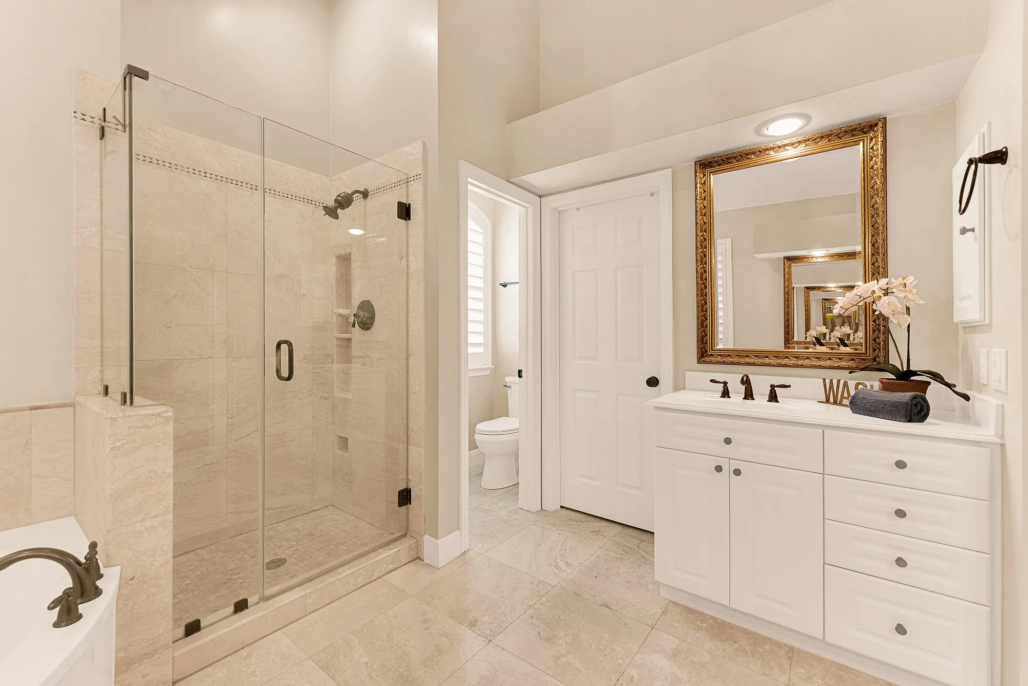 A frameless glass shower enclosure stands beside a soaking tub, accentuating clean lines and an airy atmosphere. Visualize washing away daily stress under a soothing stream of warm water
