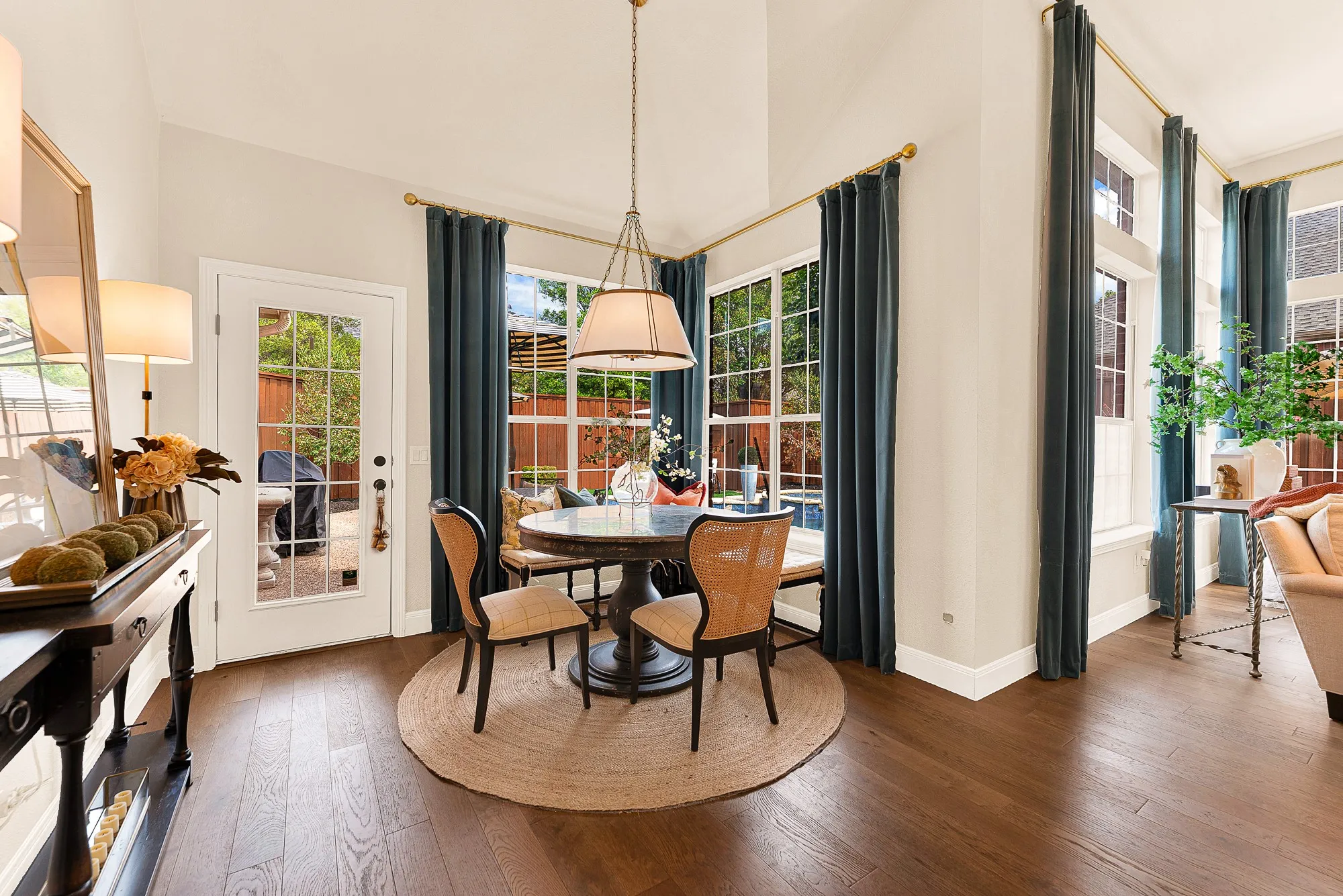 A cozy breakfast nook framed by tall windows offers direct views of the backyard and pool. Start peaceful weekend mornings with quiet coffee while watching sunlight dance across the sparkling water outside.
