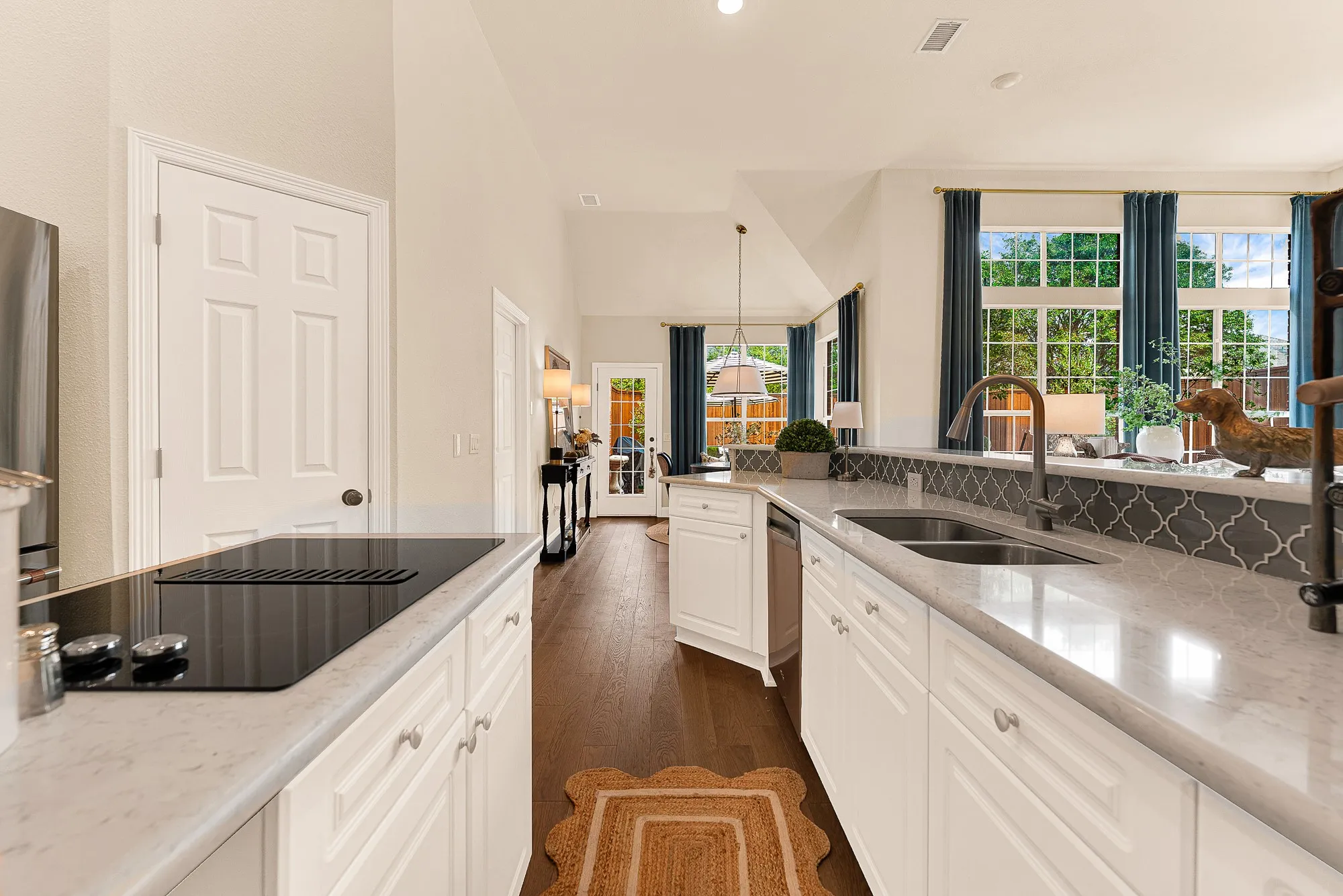 An elongated breakfast bar overlooks the main living room, maintaining open sightlines and effortless connection across spaces. Serve casual morning breakfasts or evening appetizers to guests gathered right at the counter.