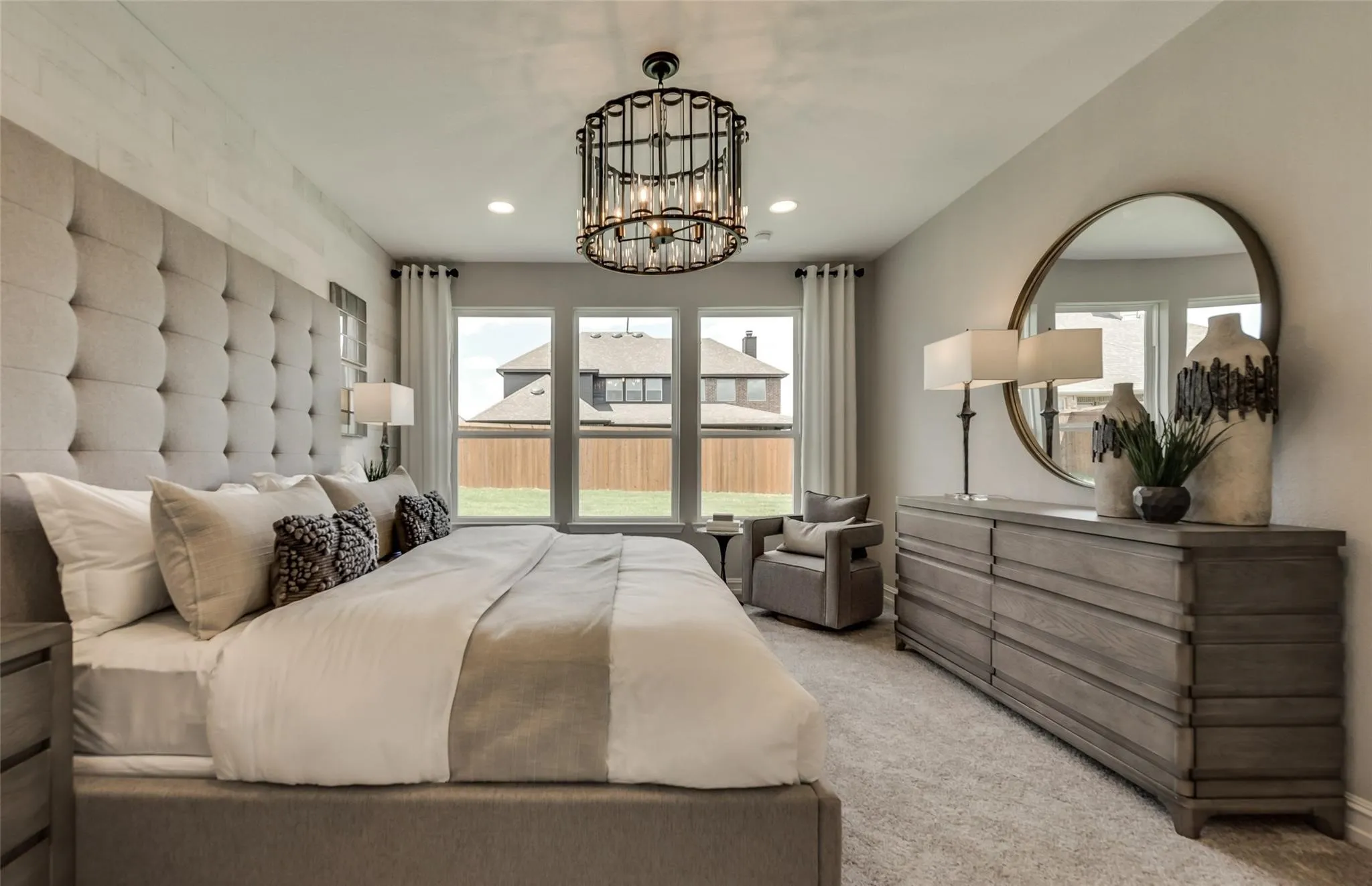 Expansive room with neutral carpeting and a decorative chandelier