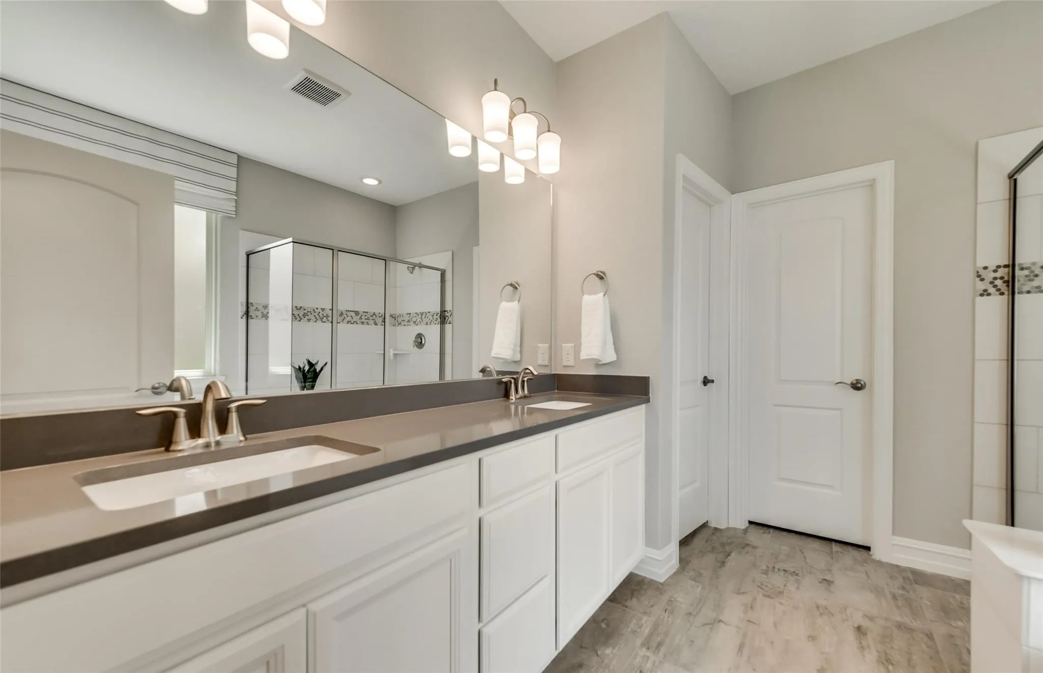Dual vanity with undermount sinks, extended countertop, and bright overhead lighting