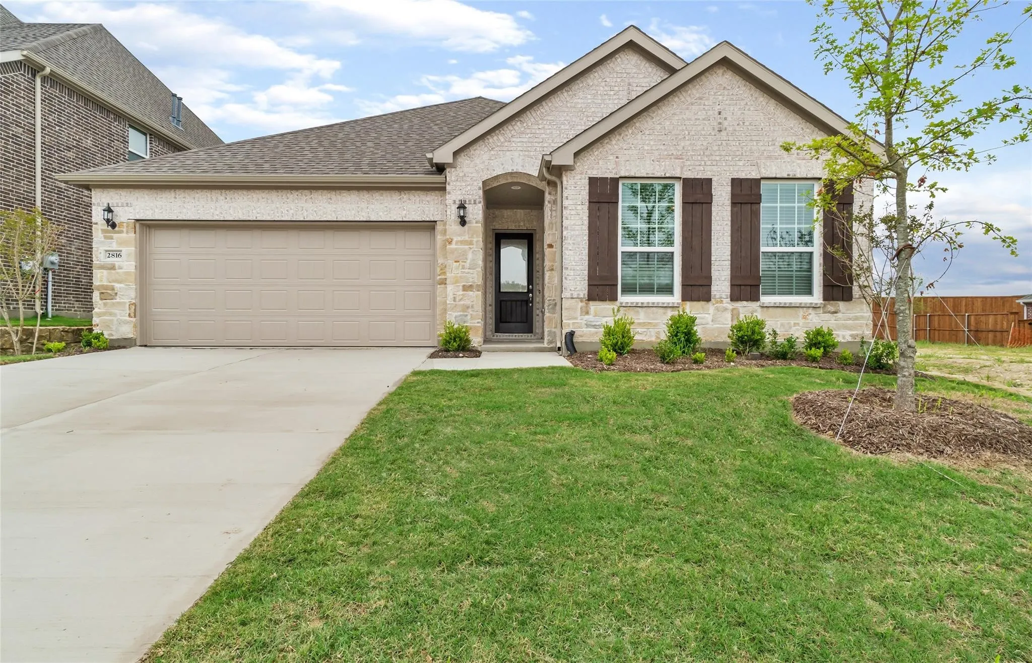 Brick and stone exterior with a two-car garage