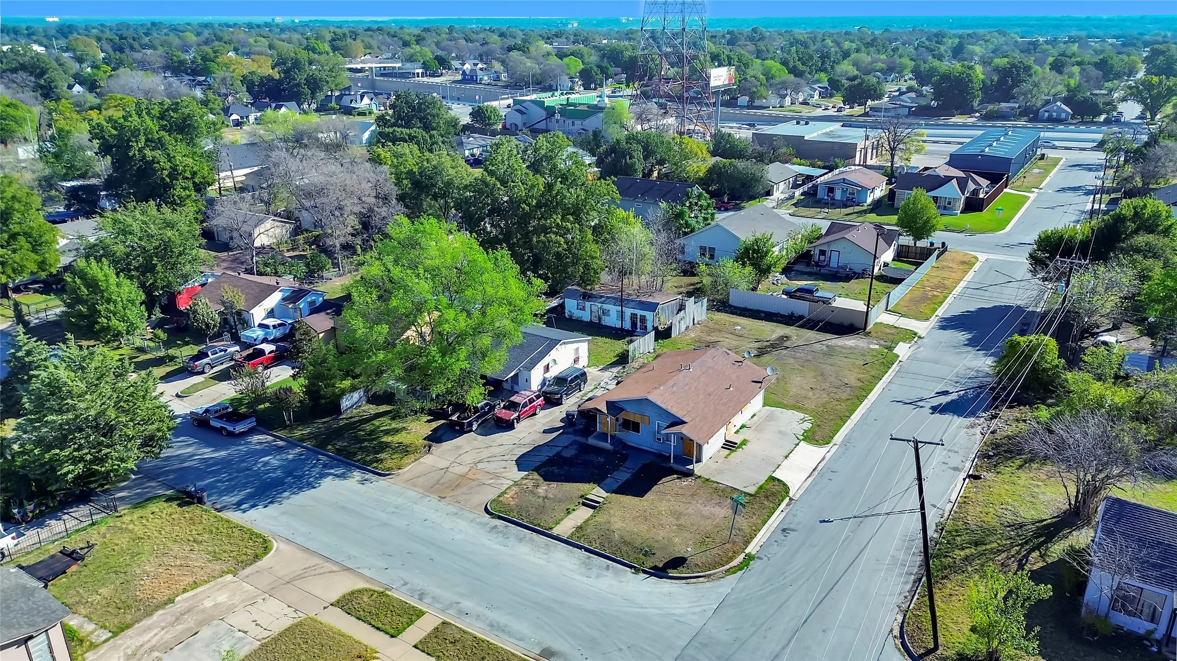 Corner lot property featuring a residential structure and surrounding green spaces
