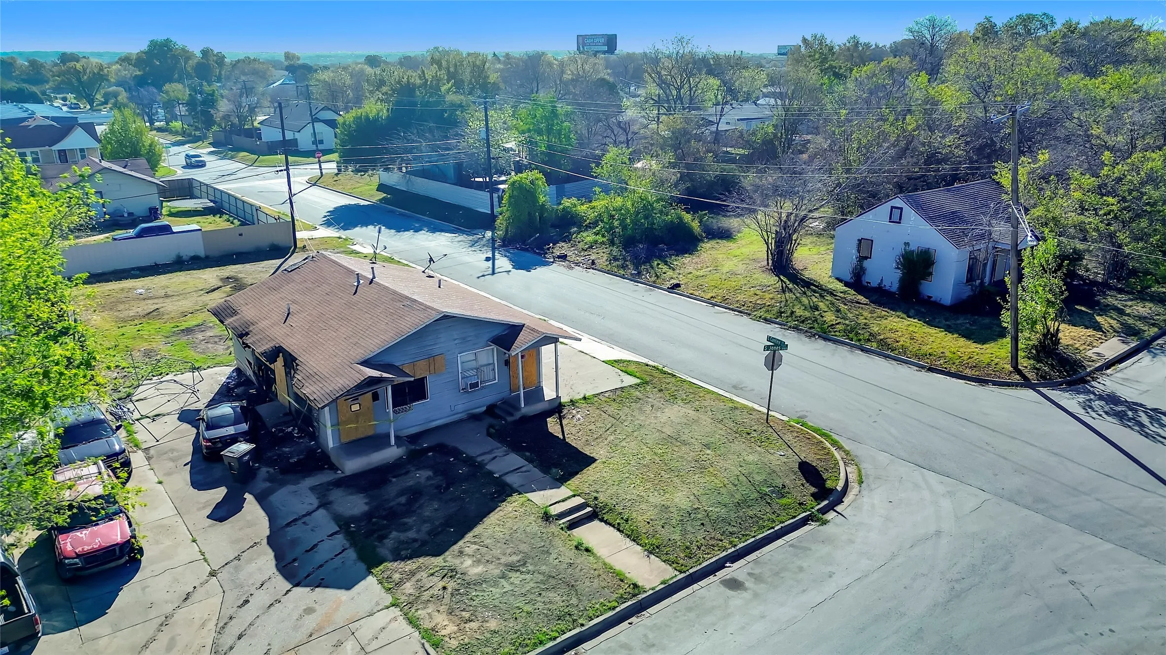 Corner lot property featuring a brown shingle roof, light blue siding, and a covered porch entry