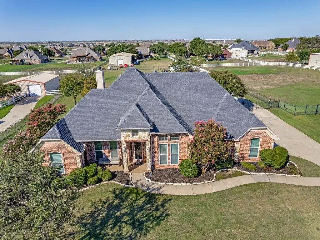 Brick and stone exterior with a gray shingle roof