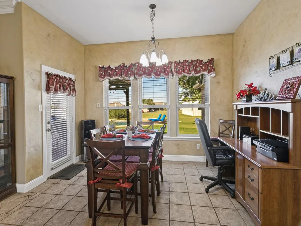 Tile flooring, multiple windows, built-in shelving, and a glass-paneled door