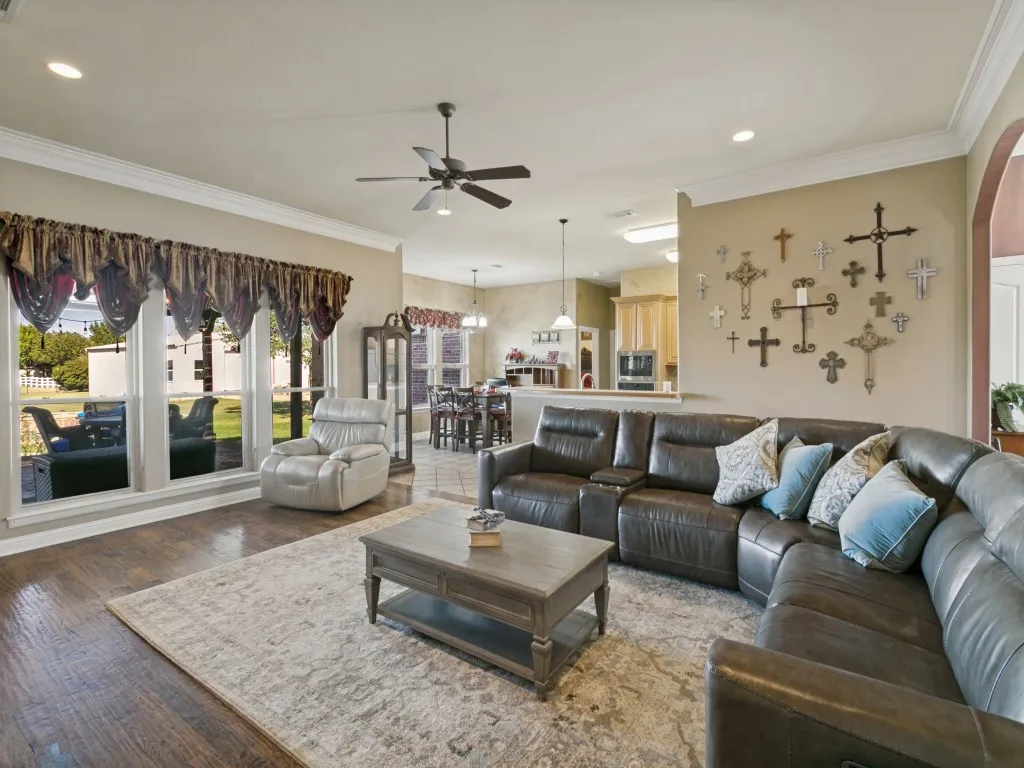 Spacious living area featuring wood-finish flooring, recessed lighting, and a ceiling fan