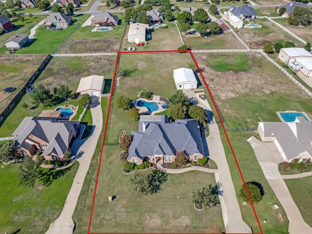 Expansive property featuring a private swimming pool, detached garage, and a long concrete driveway