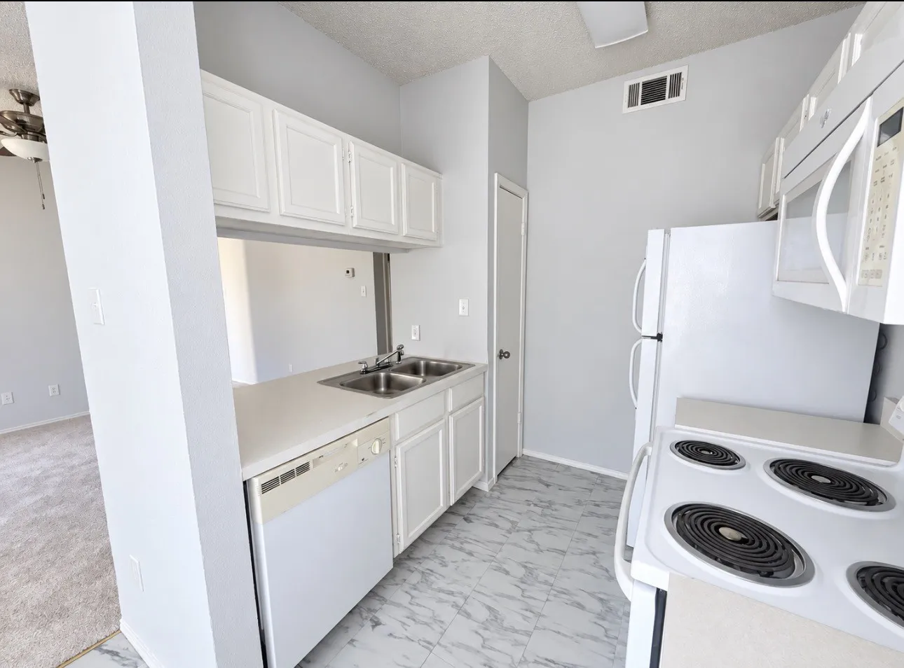 Kitchen featuring white cabinetry, dual basin stainless steel sink, white dishwasher, and white electric range