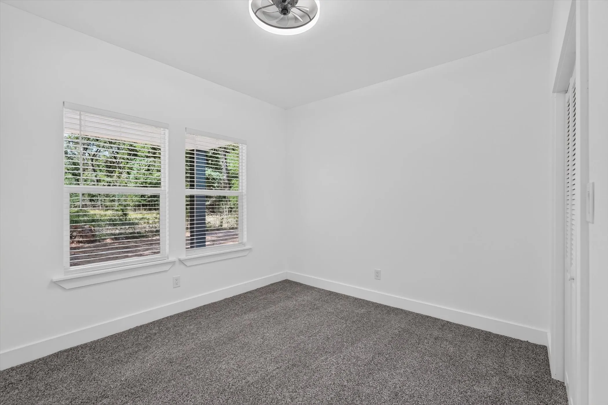 Bright interior space featuring two windows, recessed lighting, and soft carpet flooring