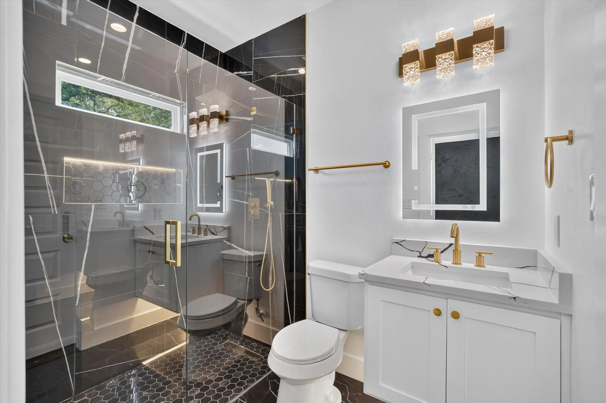 Walk-in shower with clear glass enclosure and black marble-look tile