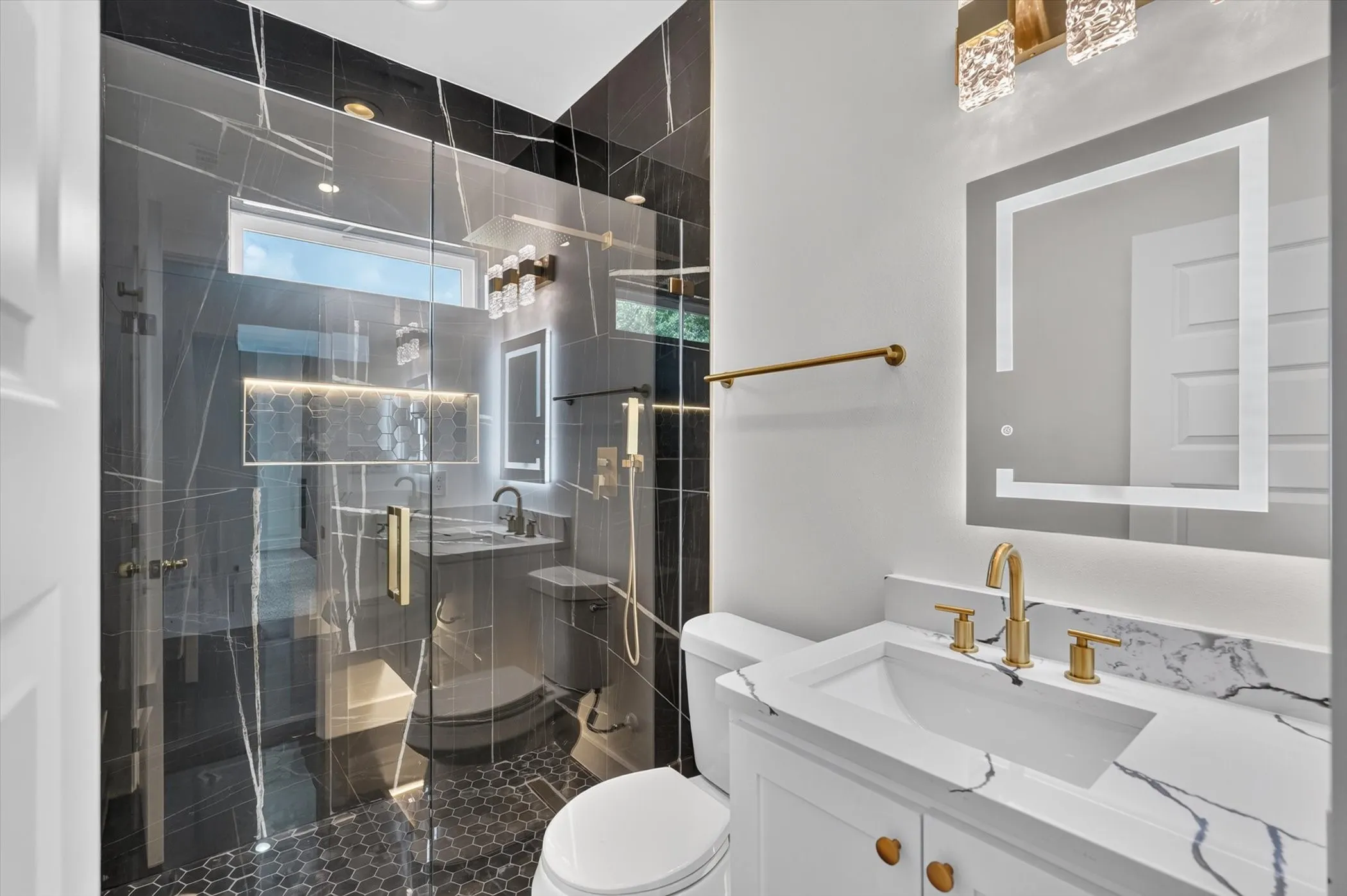 Walk-in shower with clear glass enclosure and dark-toned tile